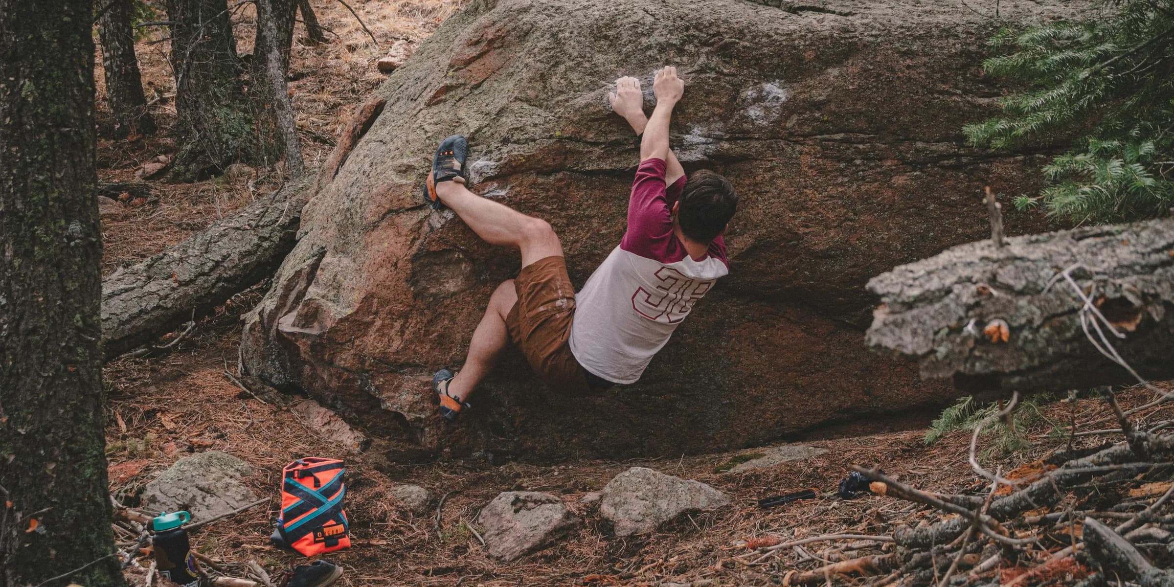 a man climbing up the side of a large rock