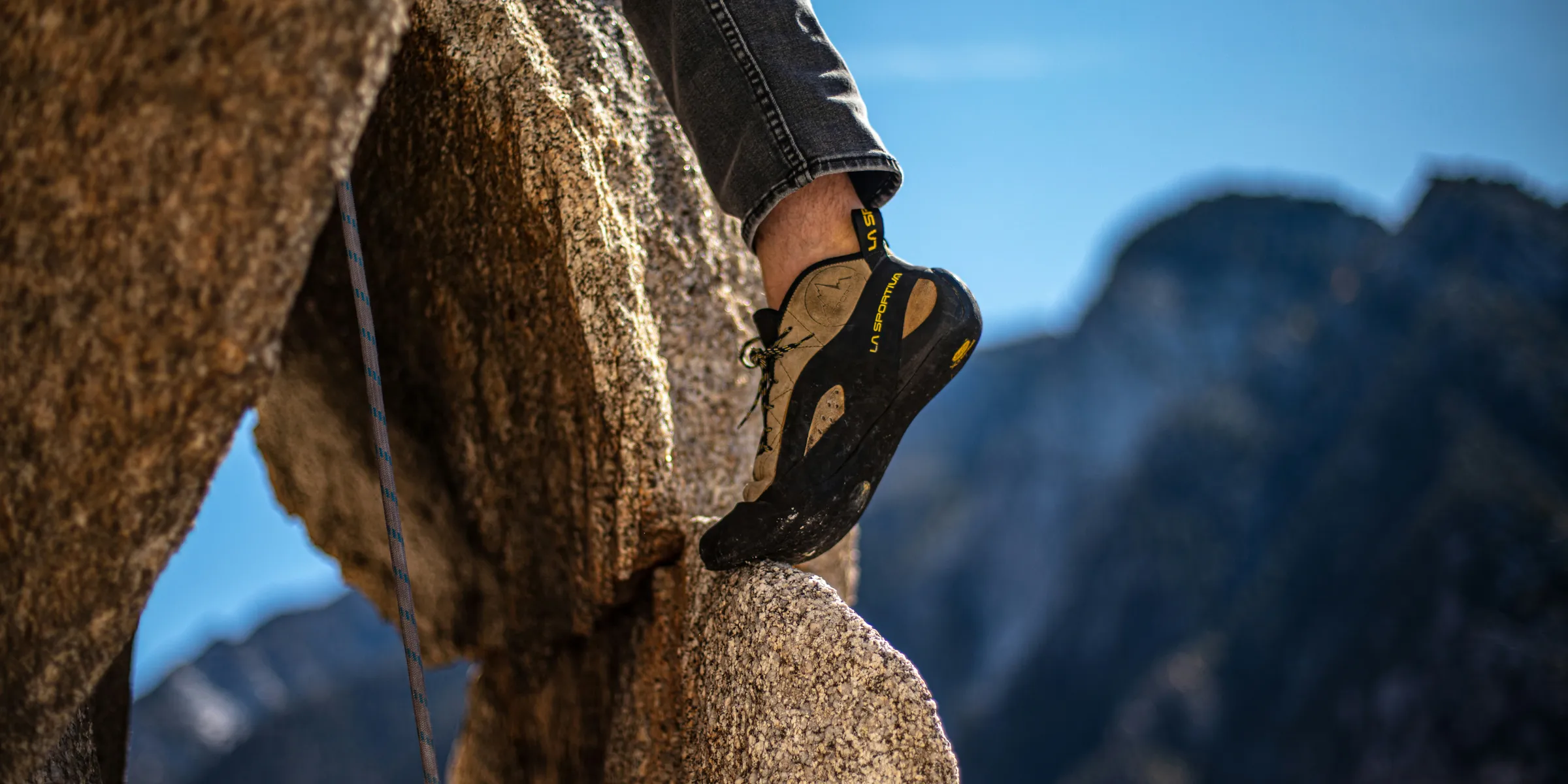 man climbing the rock formation during daytime
