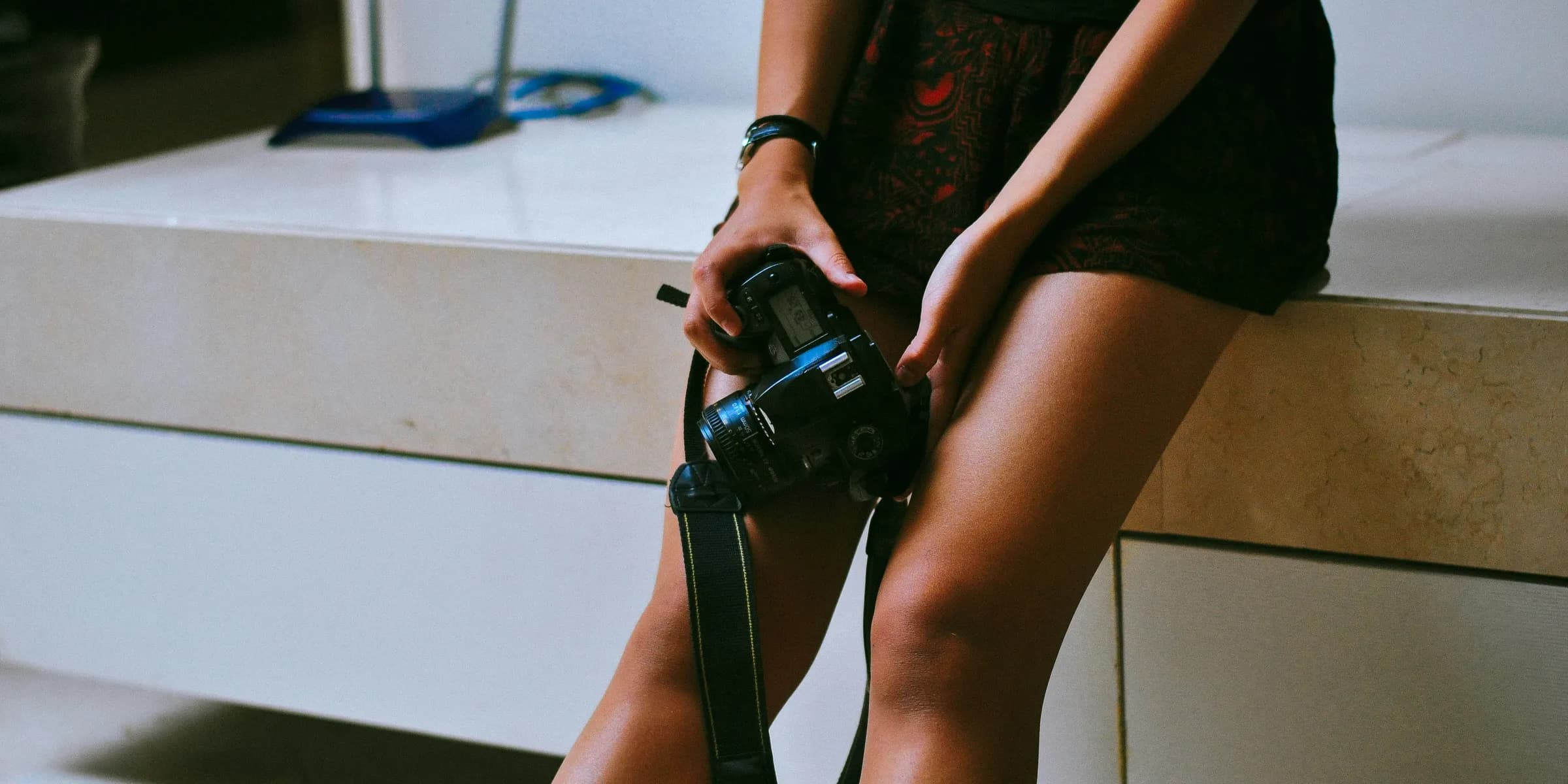 woman in black t-shirt and black shorts holding black dslr camera