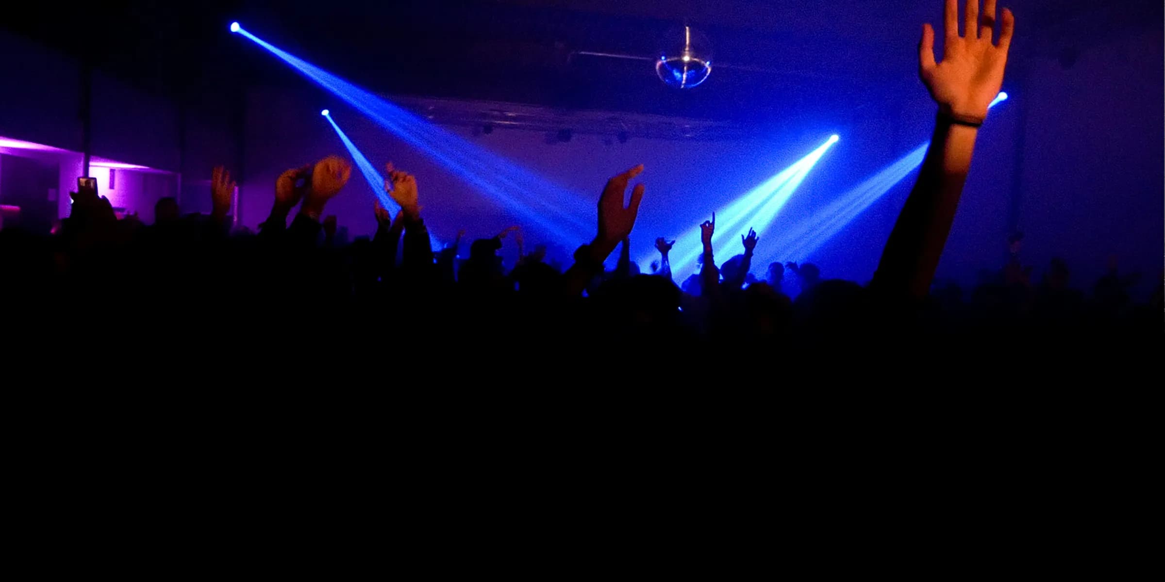 a crowd of people at a concert with their hands up