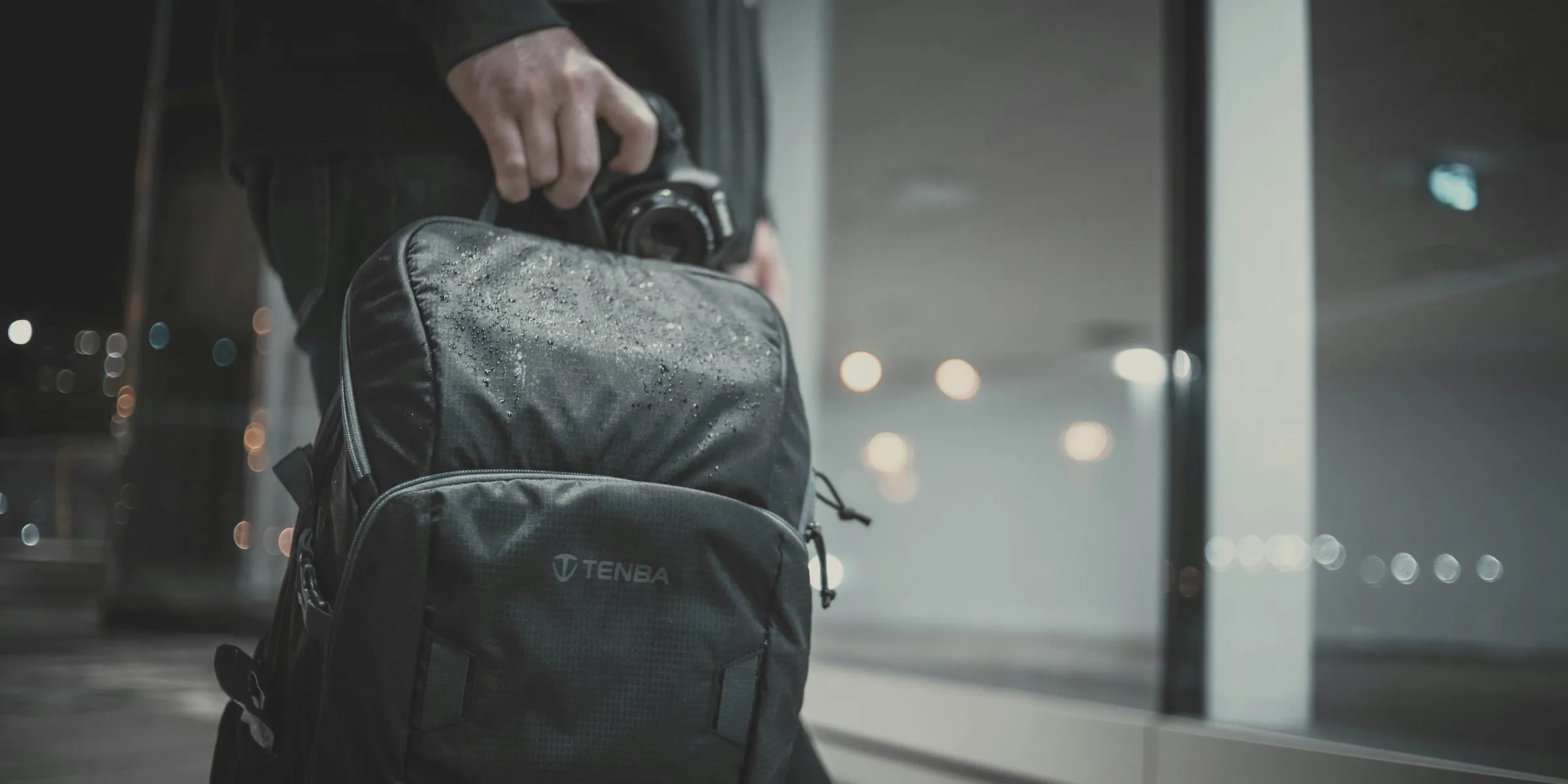 a man carrying a black backpack and a camera
