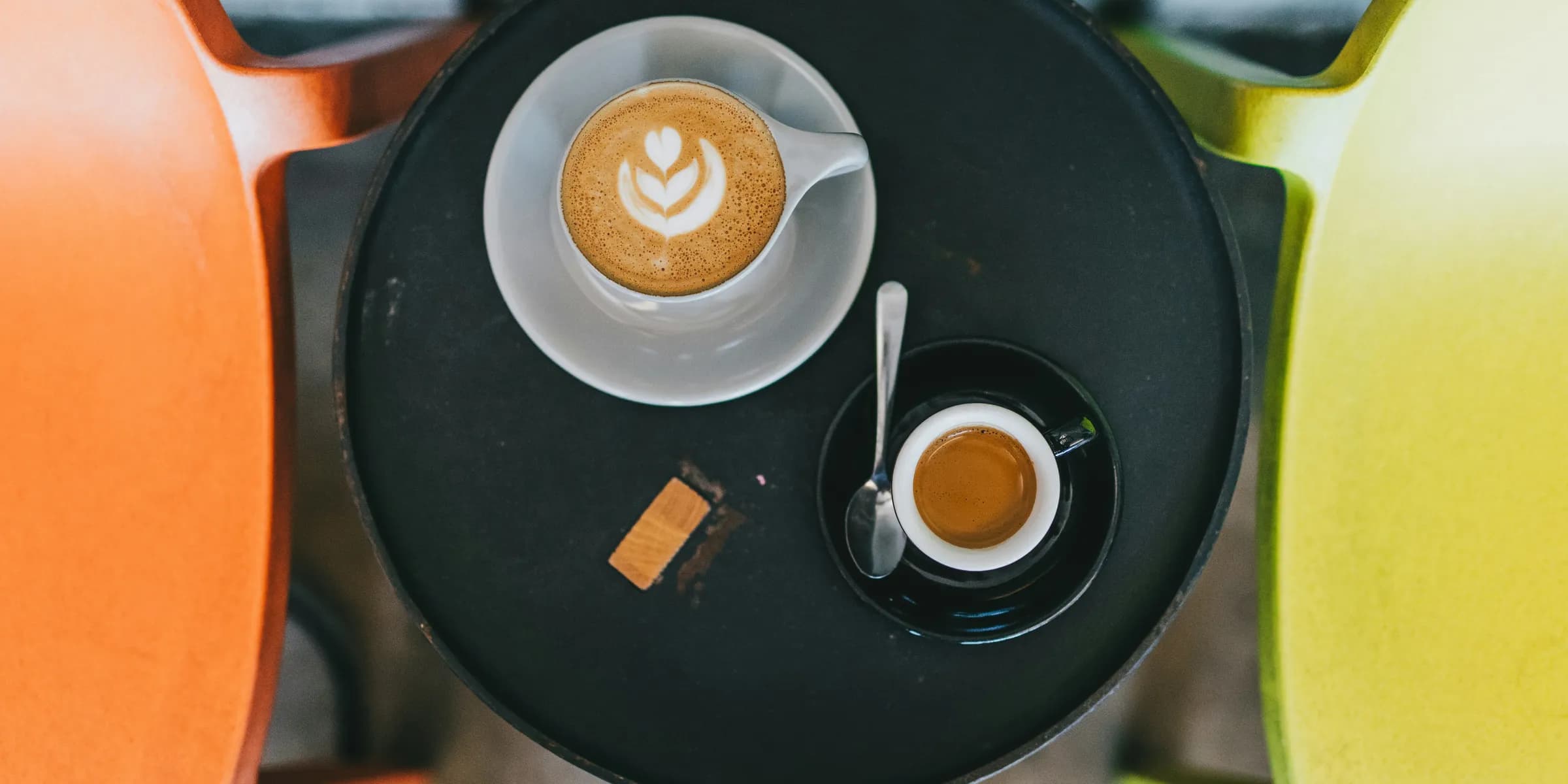 aerial photo of two cups of coffees on saucer