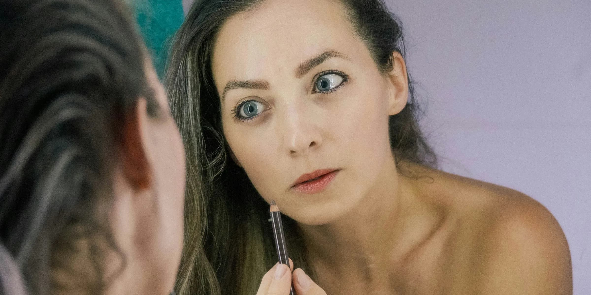 a woman is looking at her reflection in the mirror