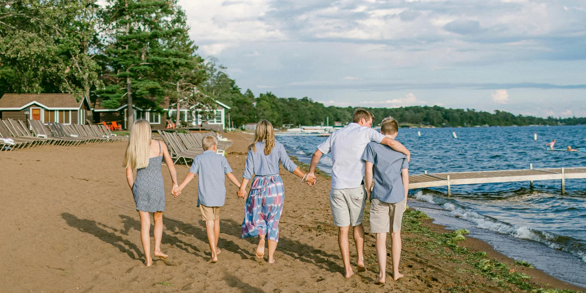a family walking on the beach holding hands