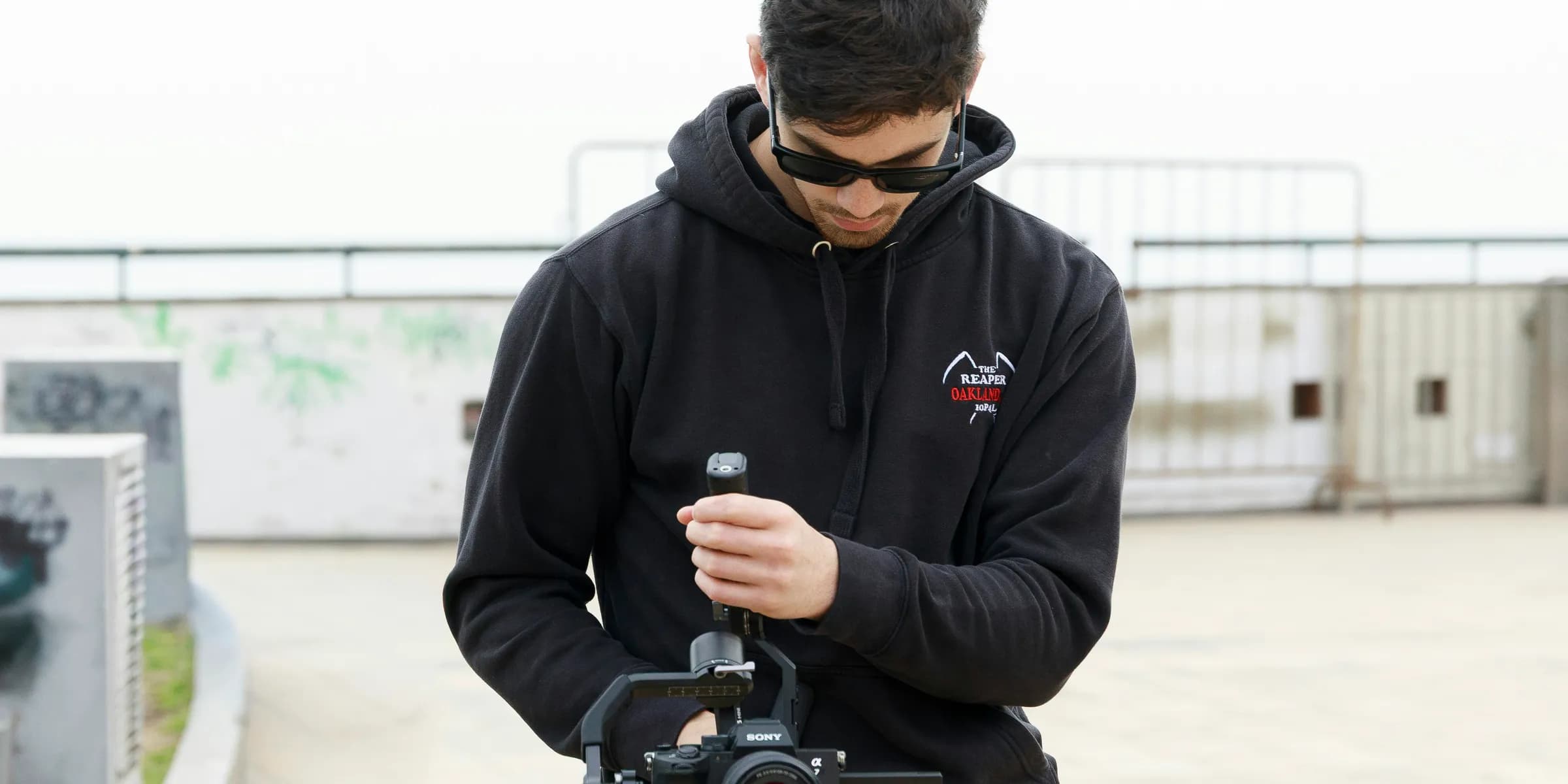 Man adjusting professional video camera equipment outdoors