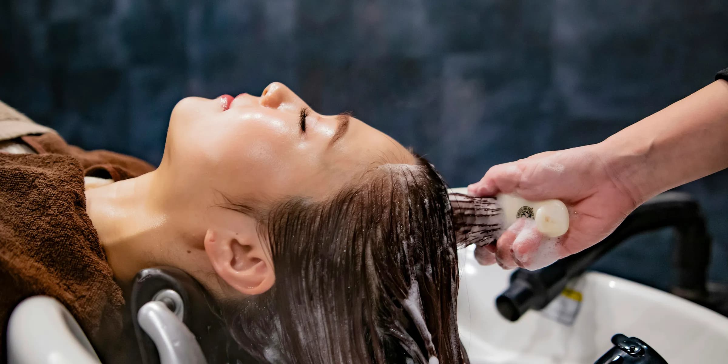 a woman getting her hair washed in a salon