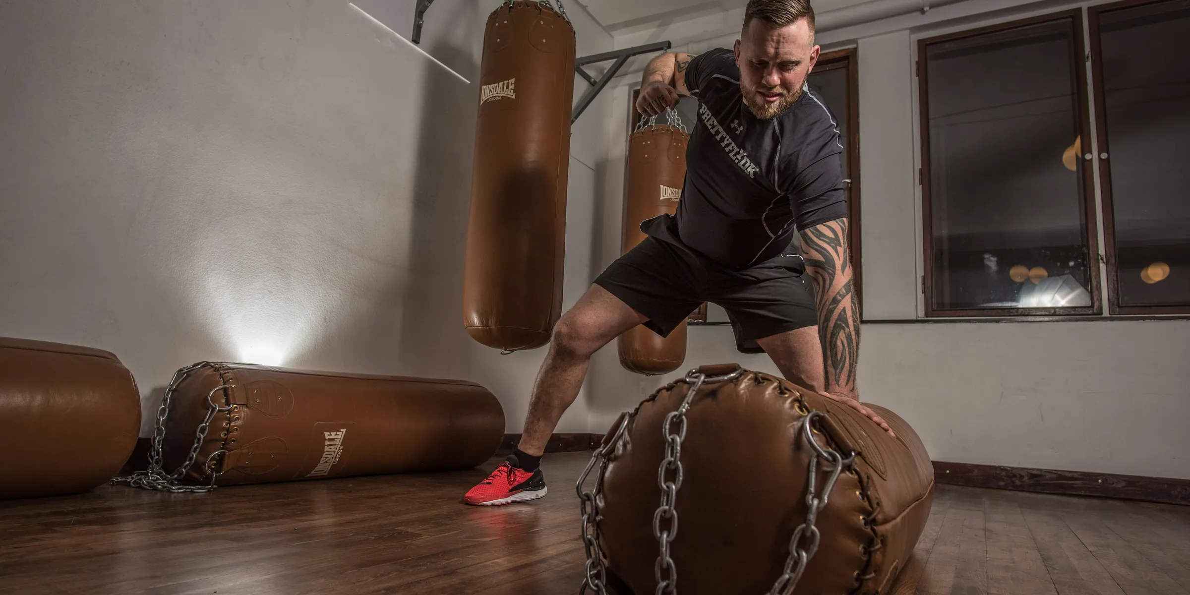 man punching brown leather heavy bag