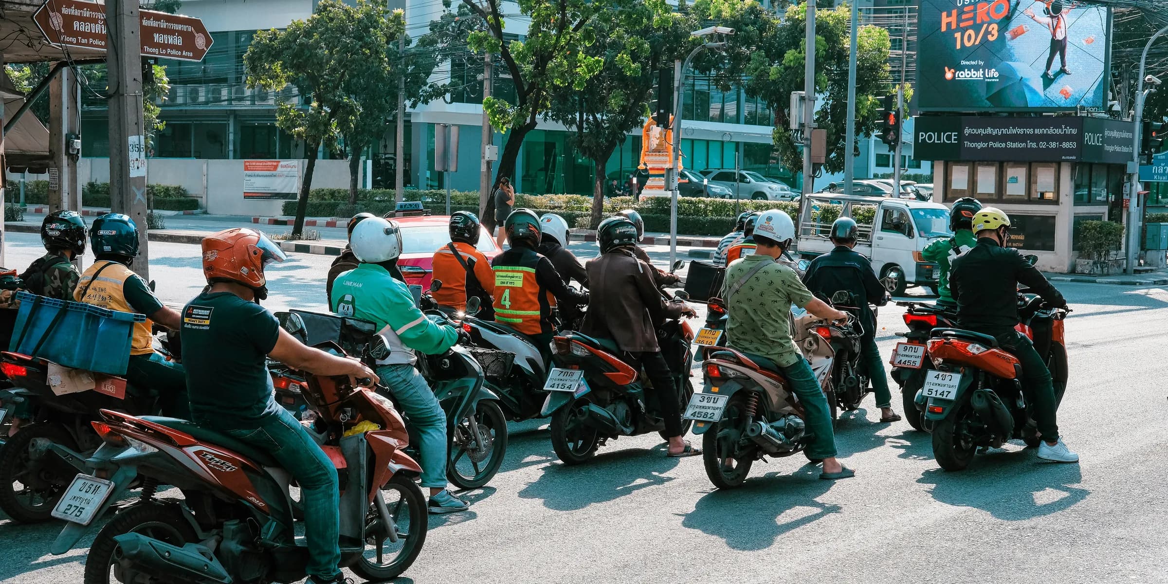 A group of people riding motorcycles down a street