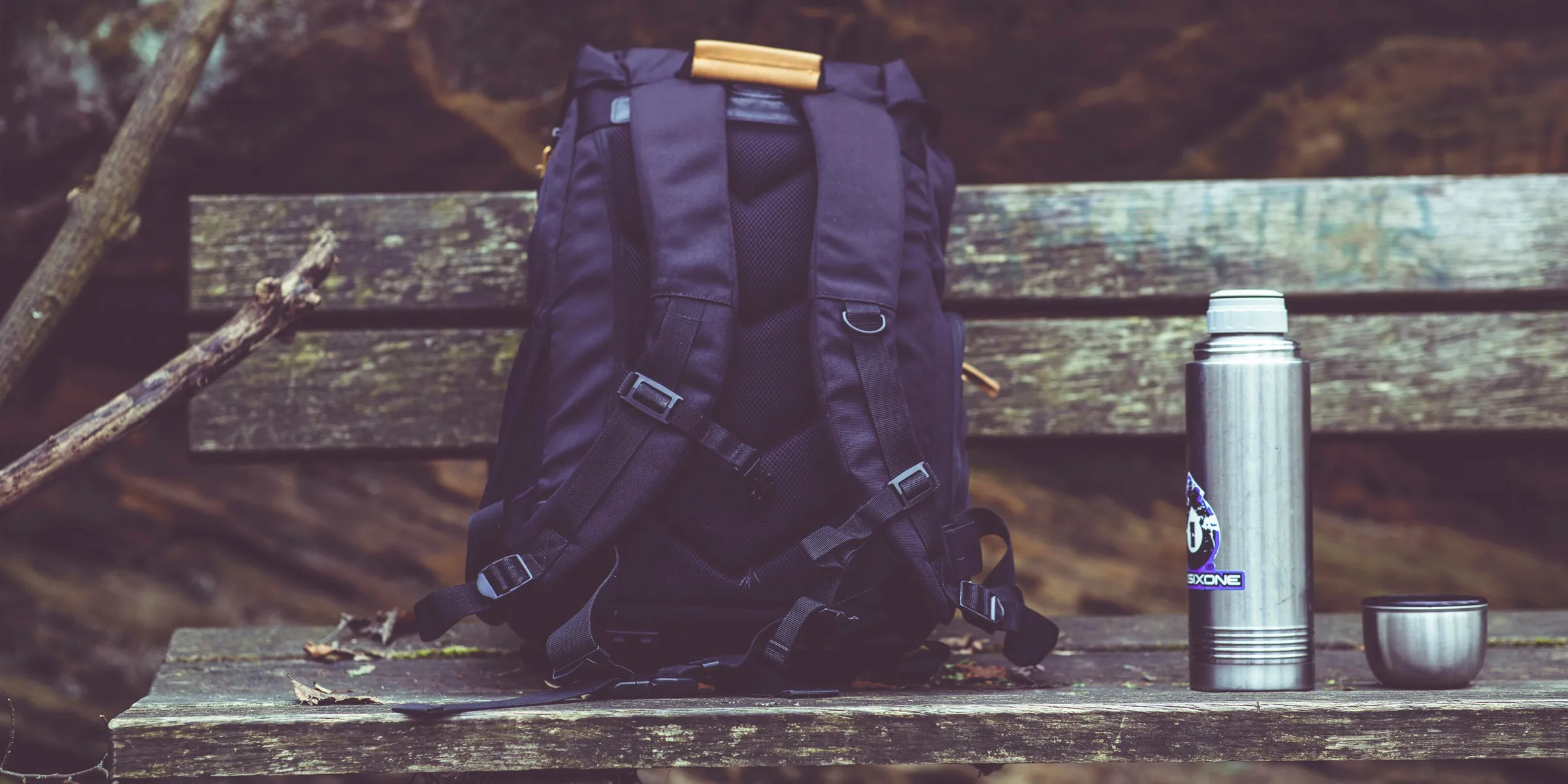 a backpack sitting on top of a wooden bench