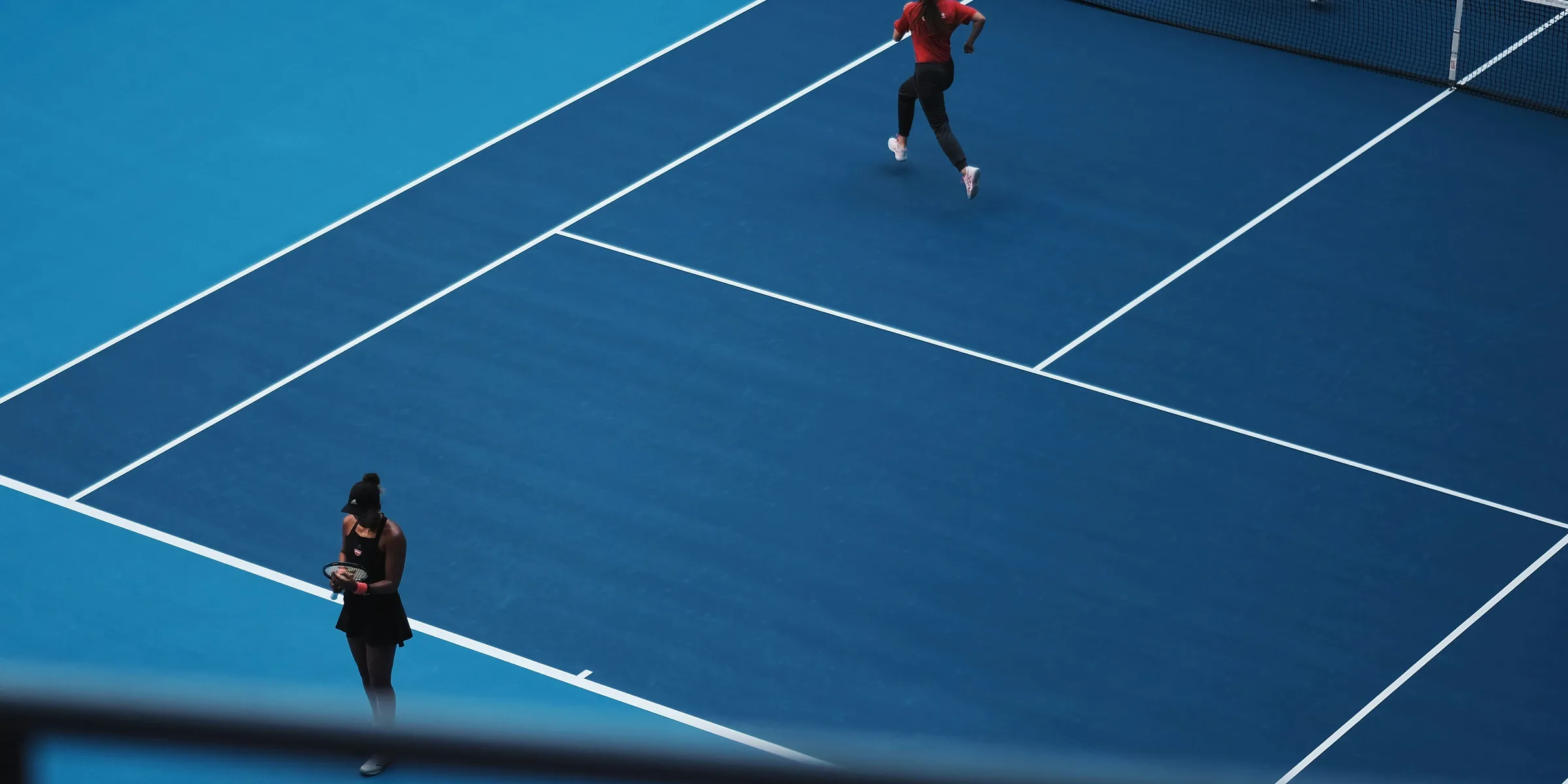 two person playing tennis during daytime