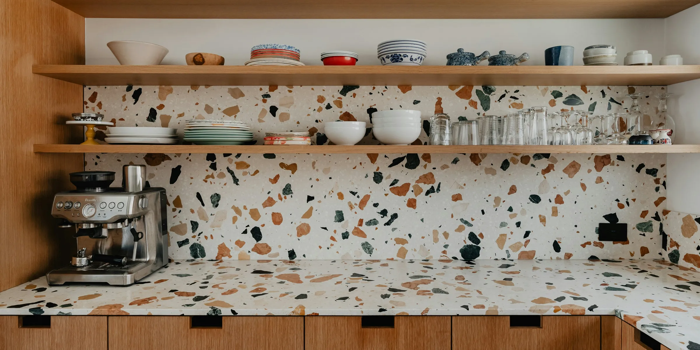 a kitchen counter with a coffee maker and cups on it