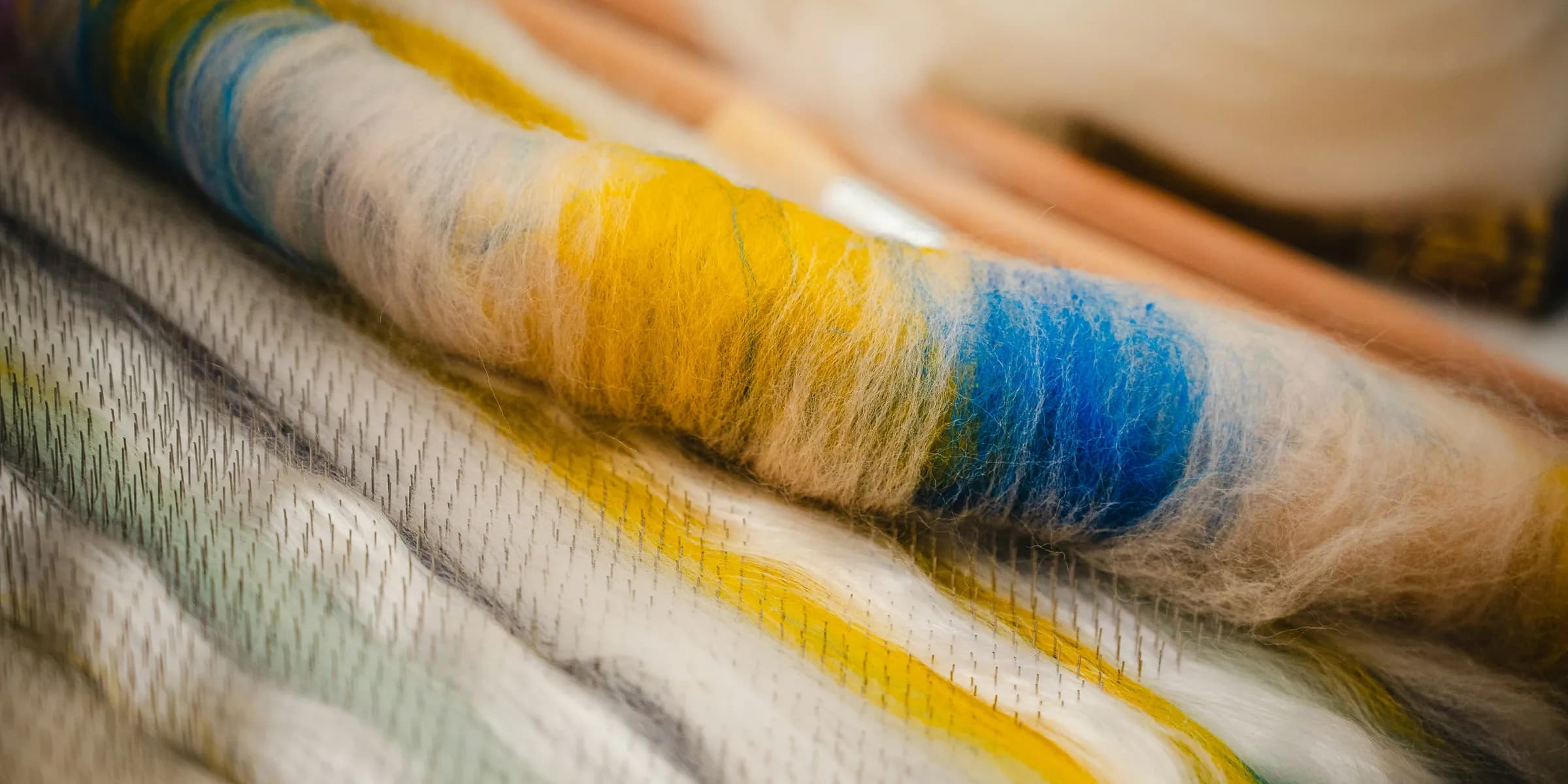 Colorful yarn and knitting needles are artfully arranged.