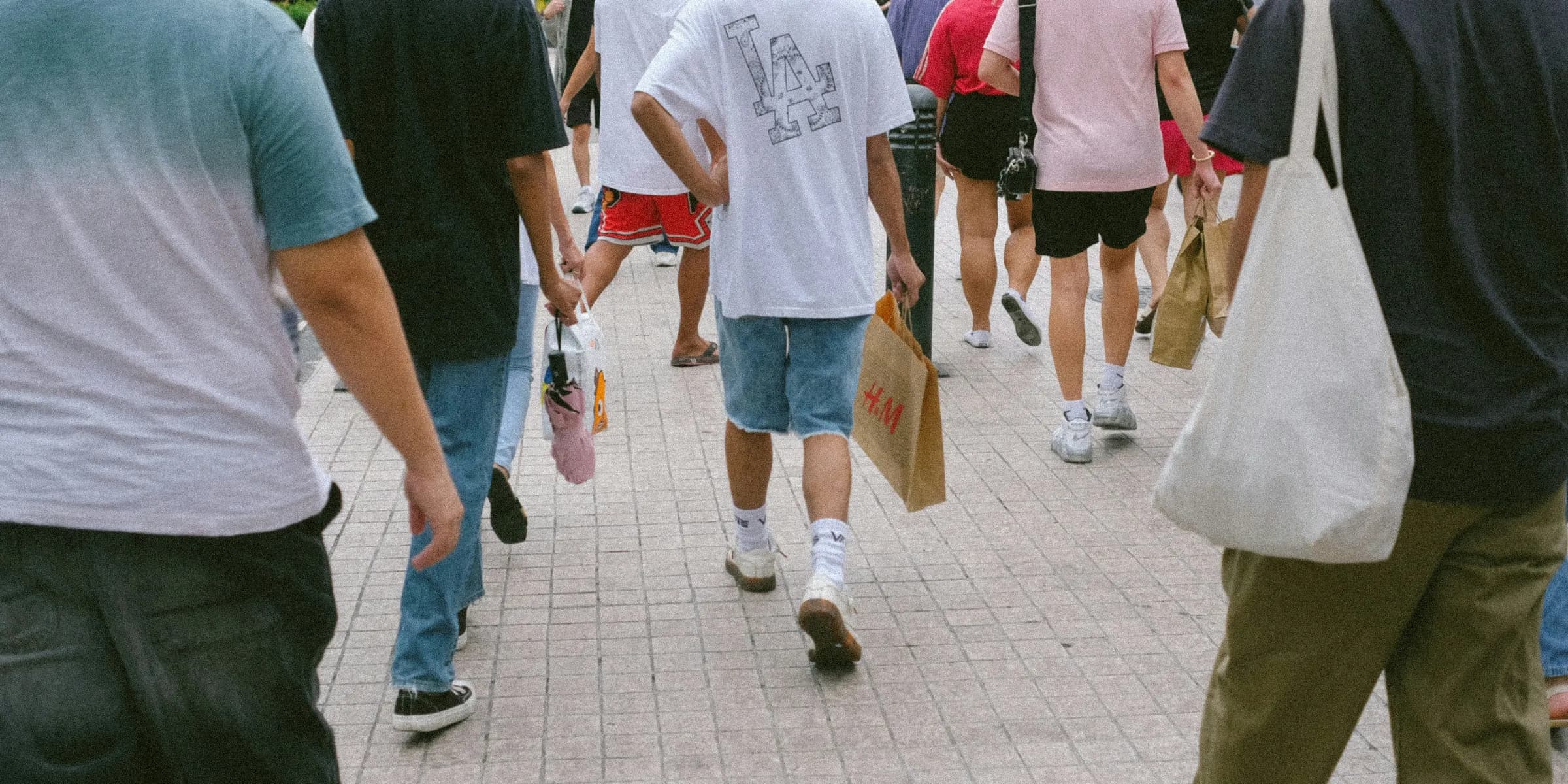 A group of people walking down a sidewalk