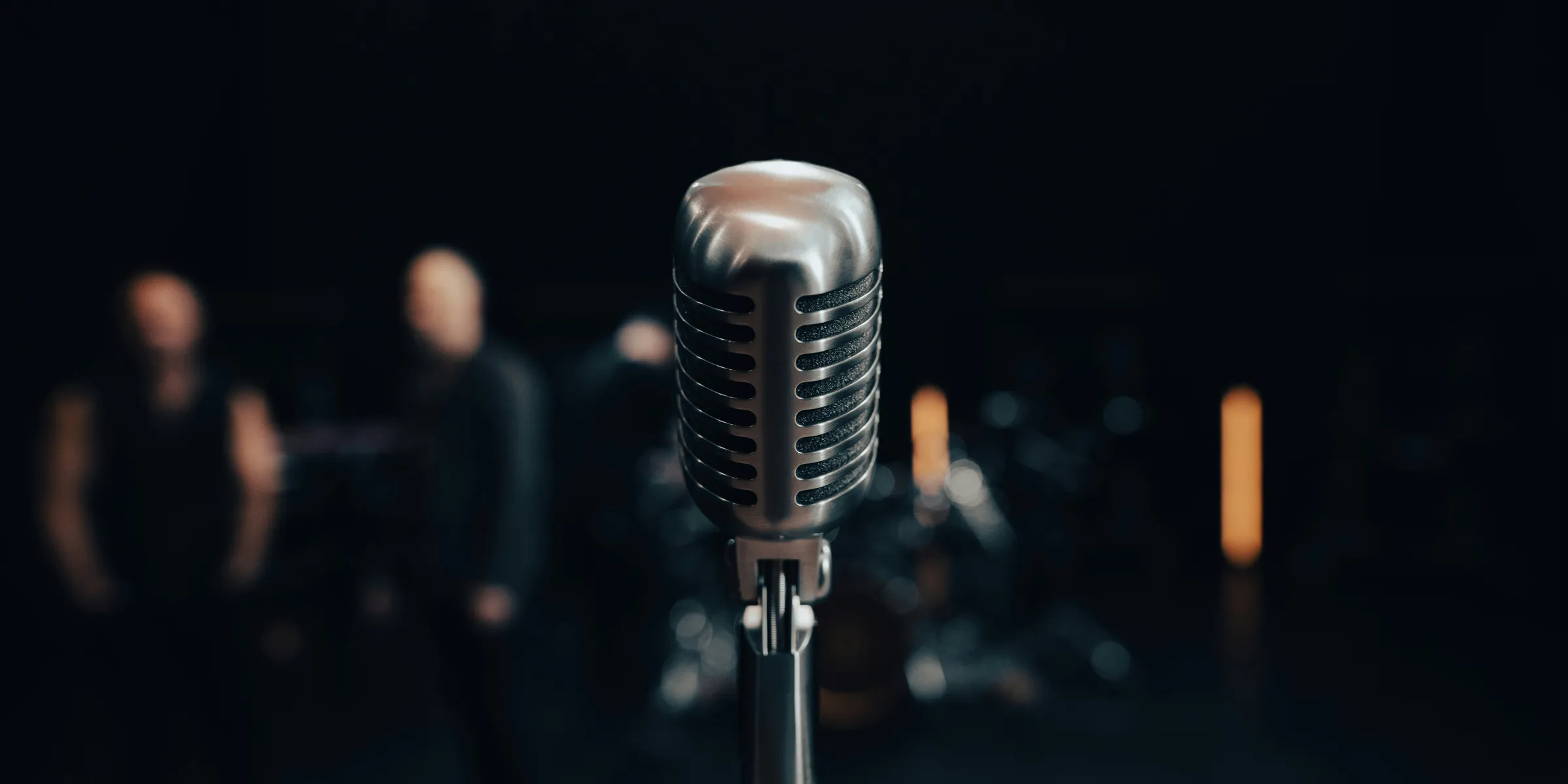 a microphone with a band in the background