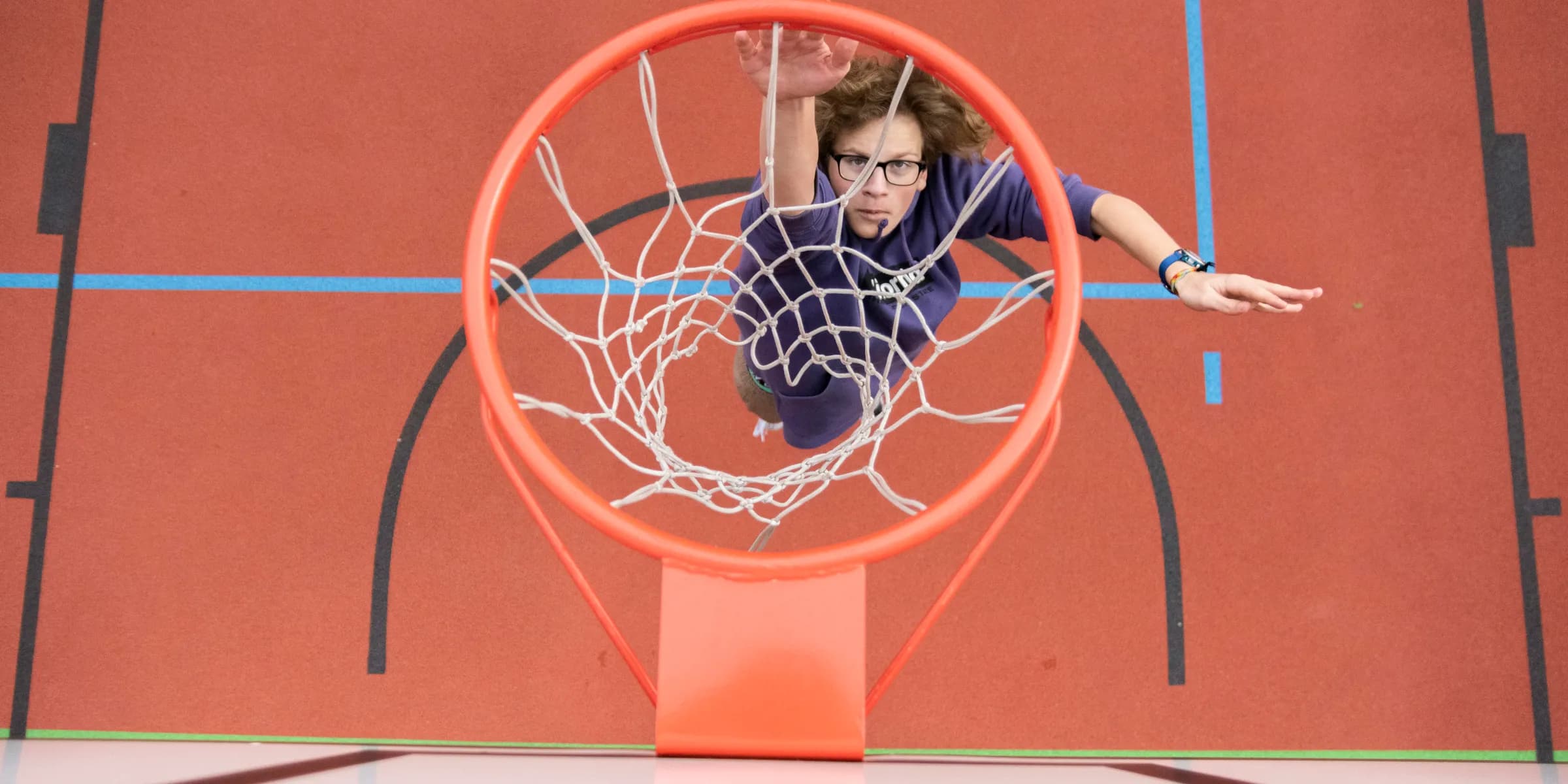 woman in black shirt sitting on basketball hoop
