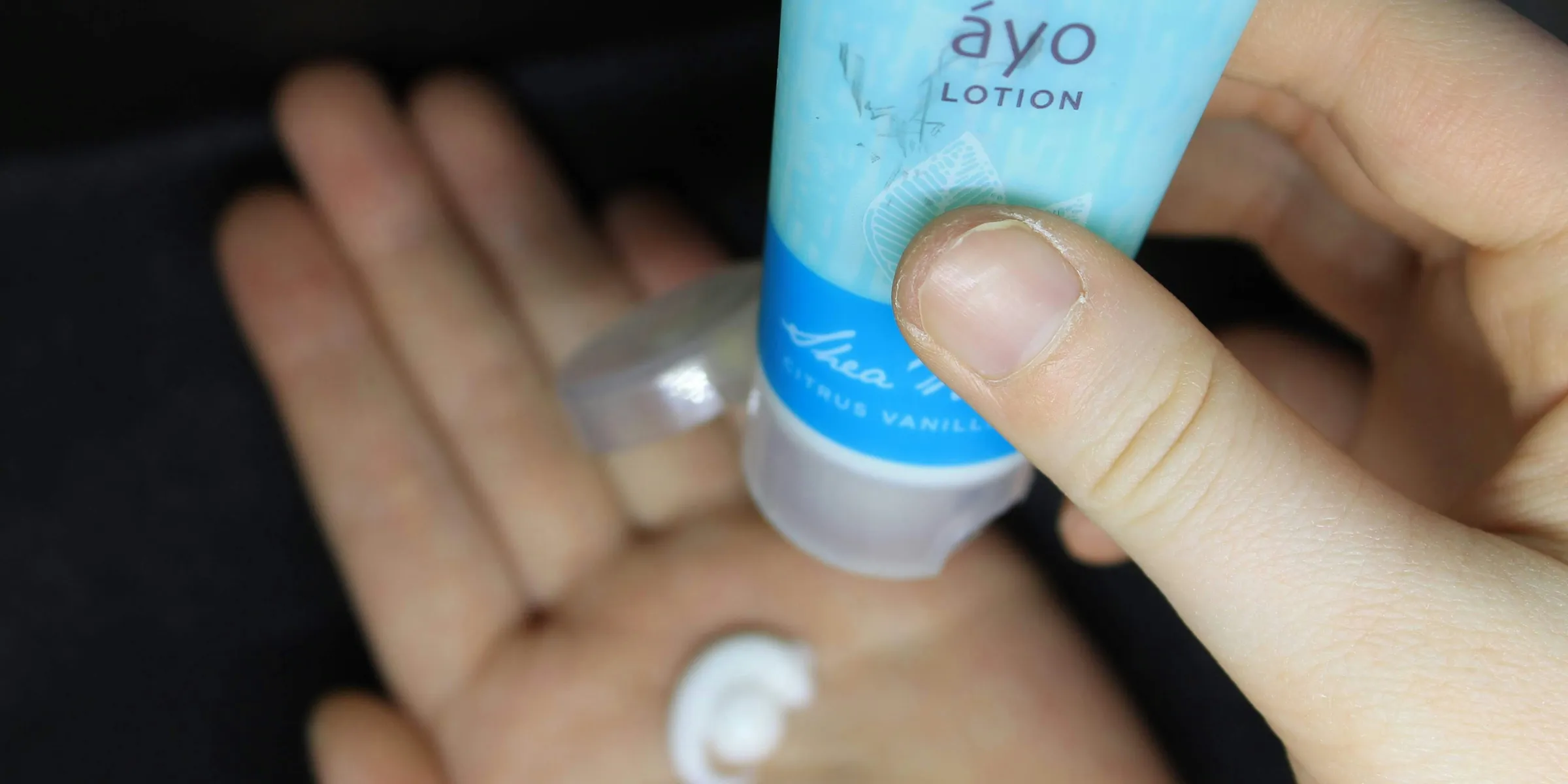 person holding white and blue plastic tube bottle
