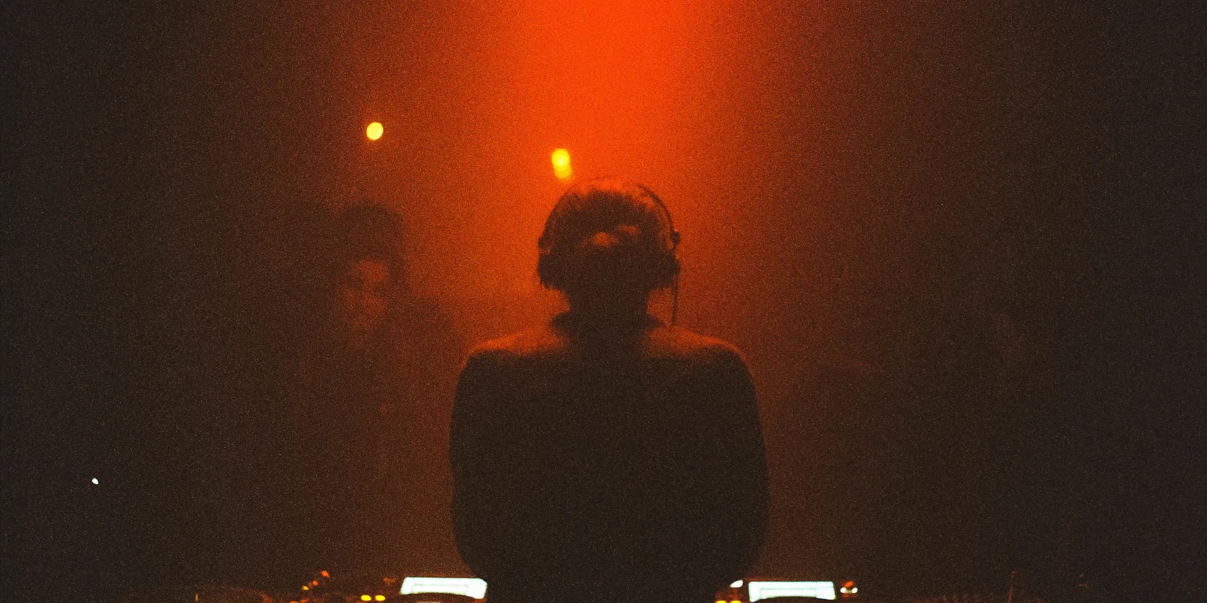 a woman standing in front of a dj set