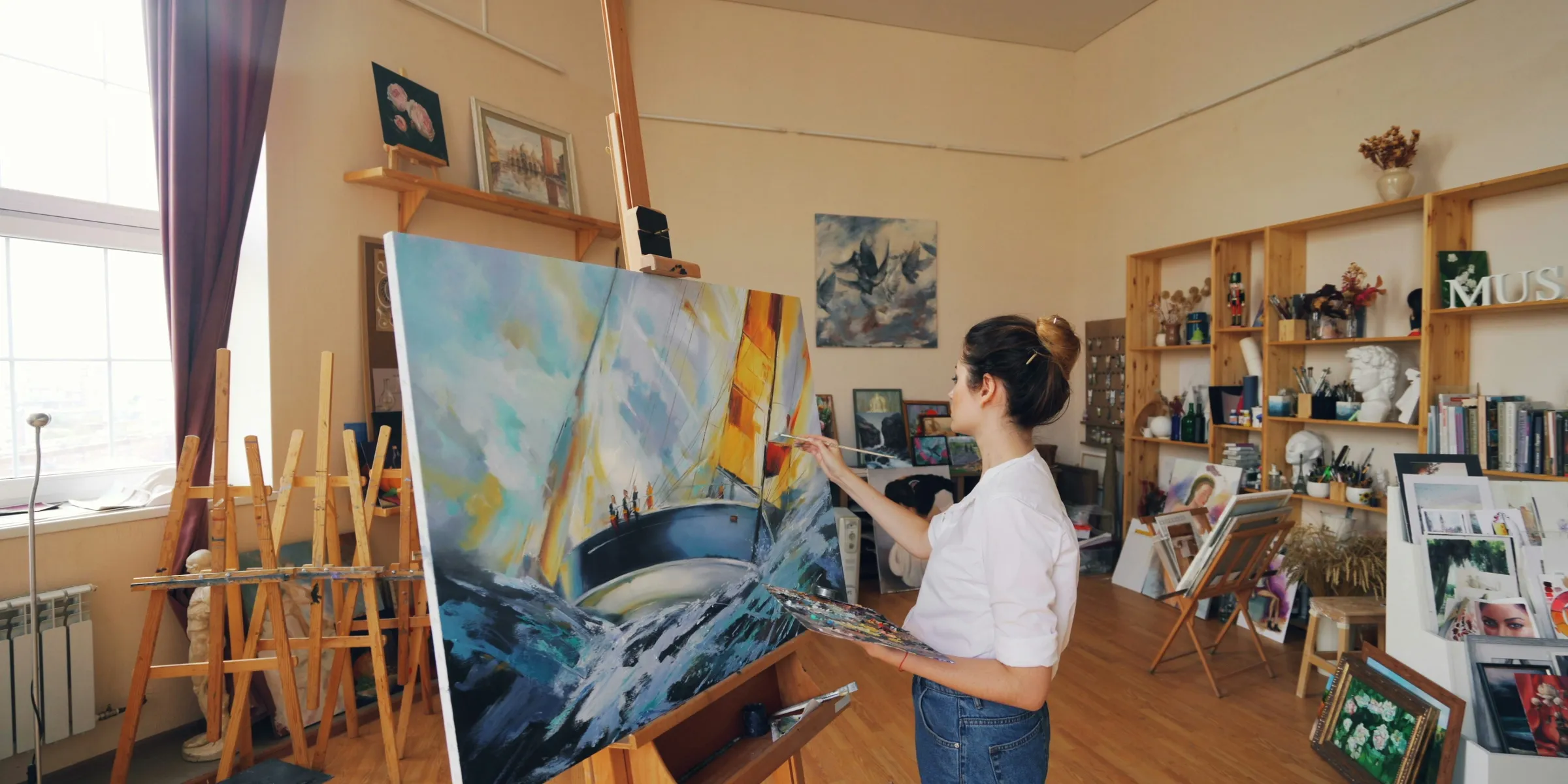 A woman paints a painting in her studio.