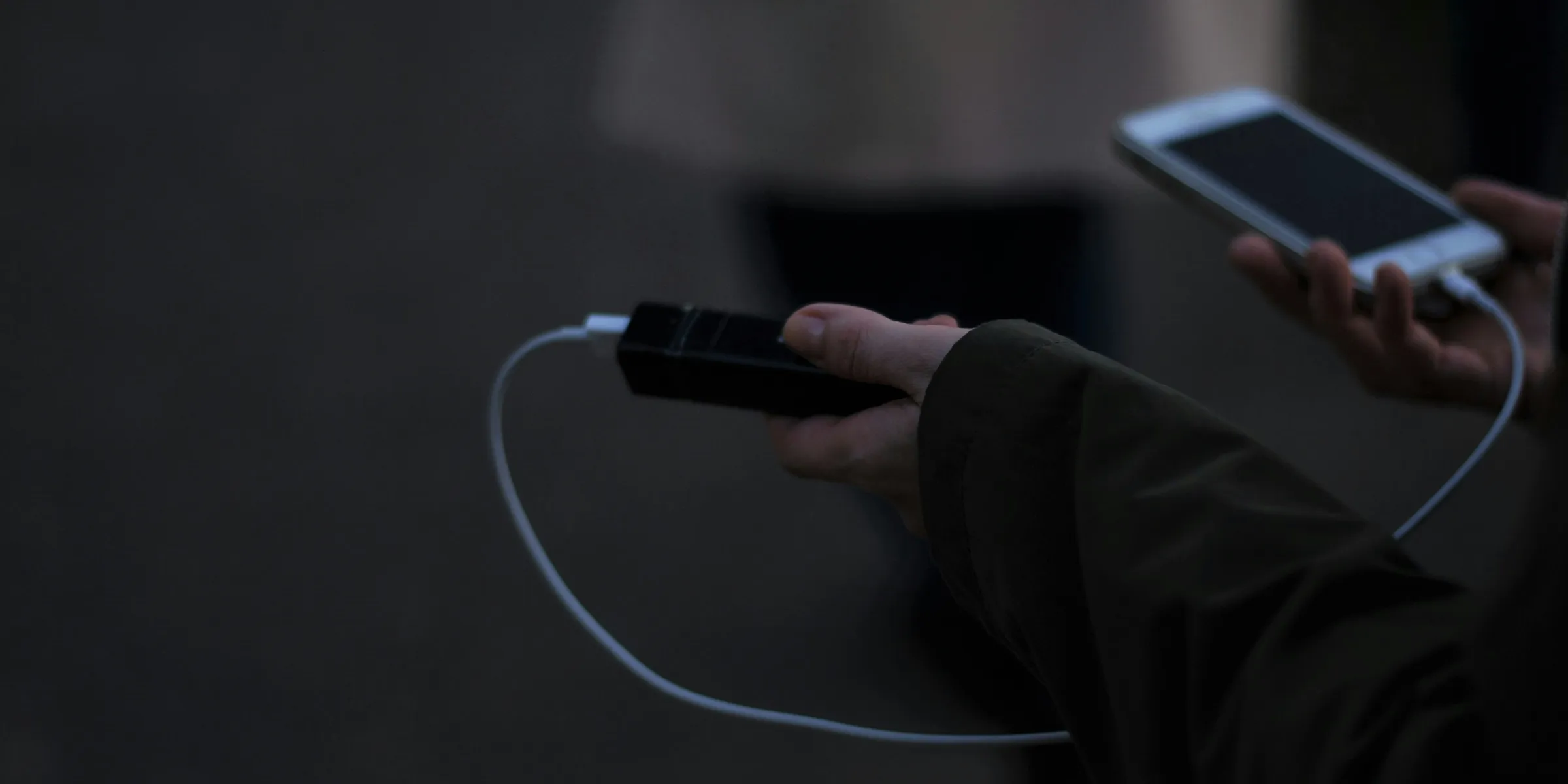 a person holding a cell phone and a charger