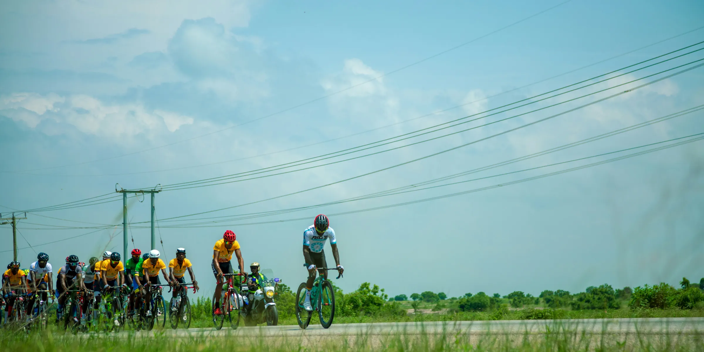Cyclists compete in a race on a sunny day.