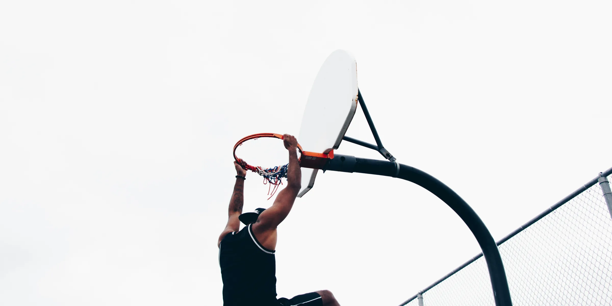 close-up photography of man dunking on basketball hop