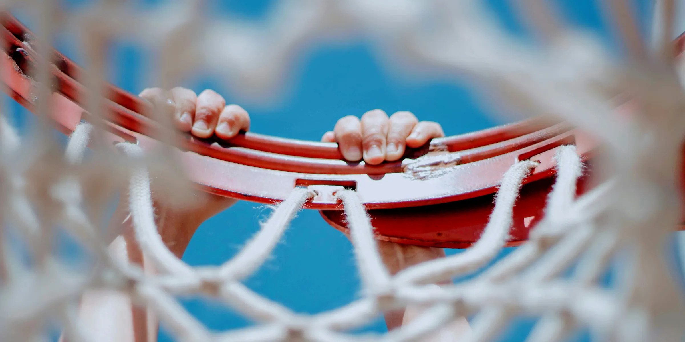 person hanging on red basketball hoop