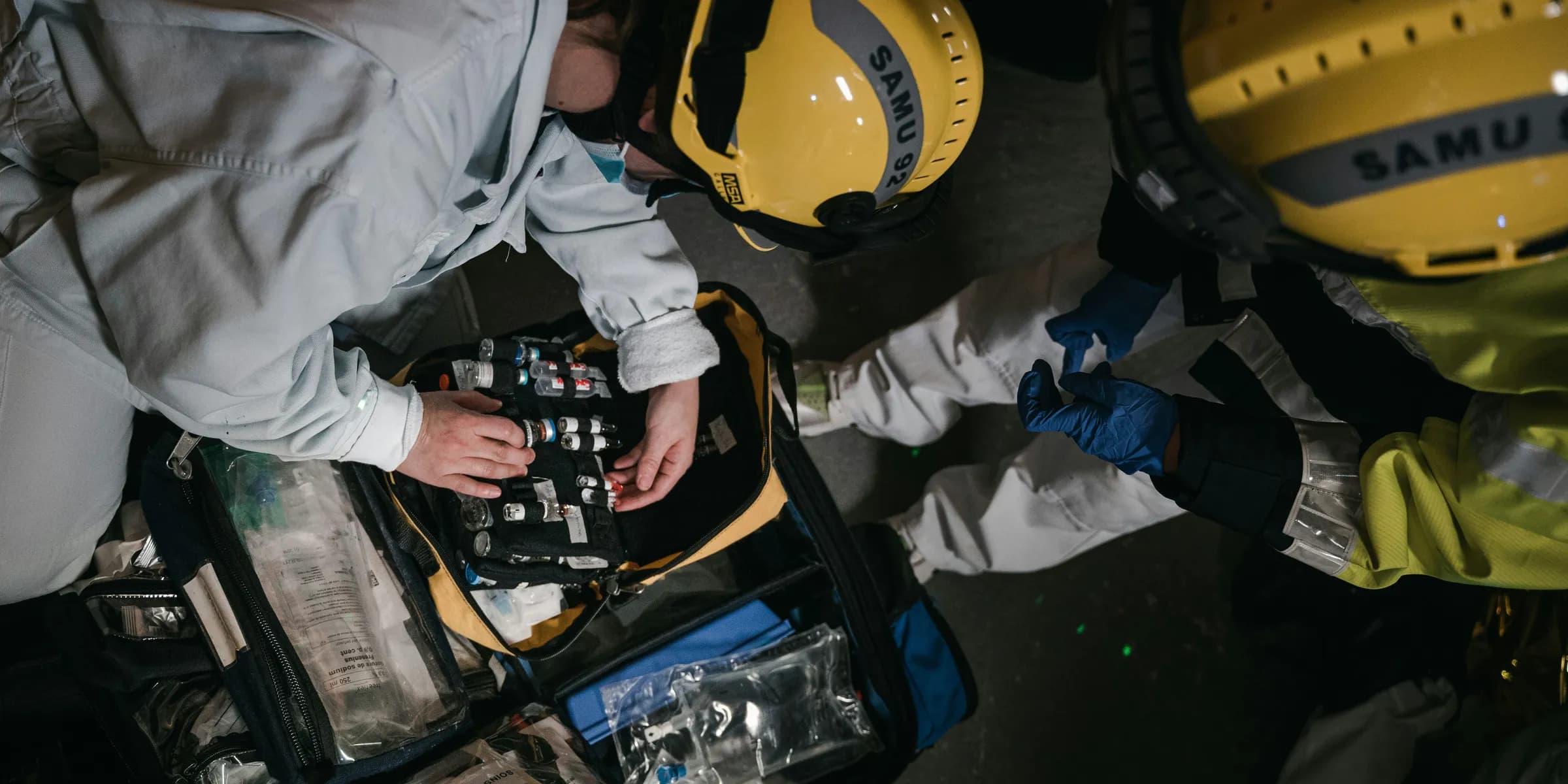 two people in hard hats working on a piece of equipment