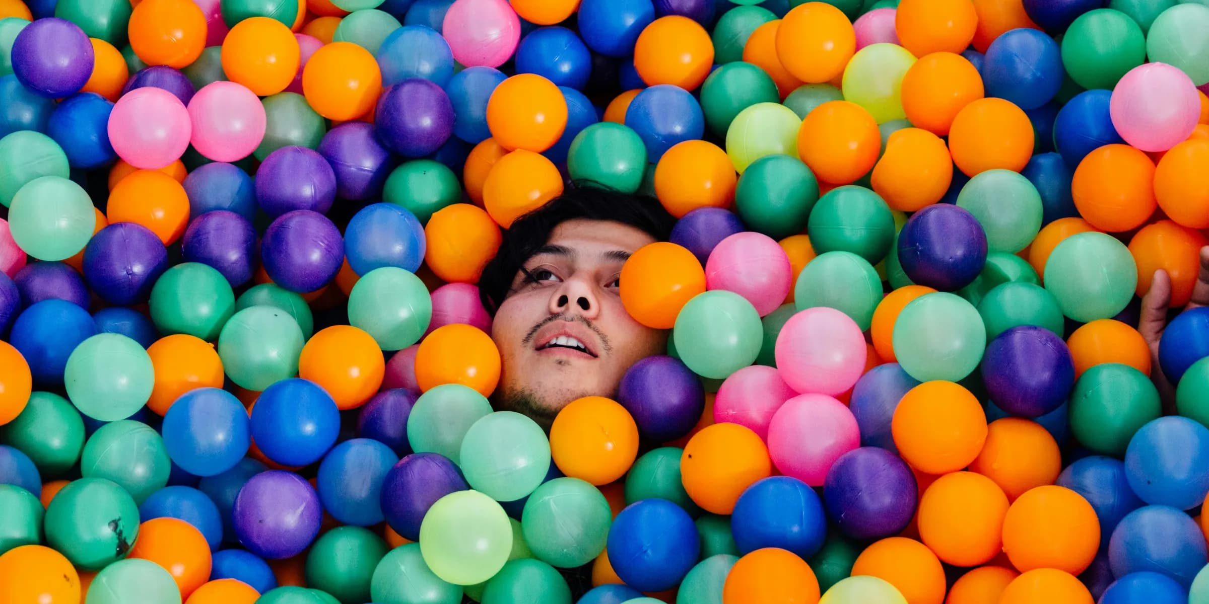 man lying in ball pit