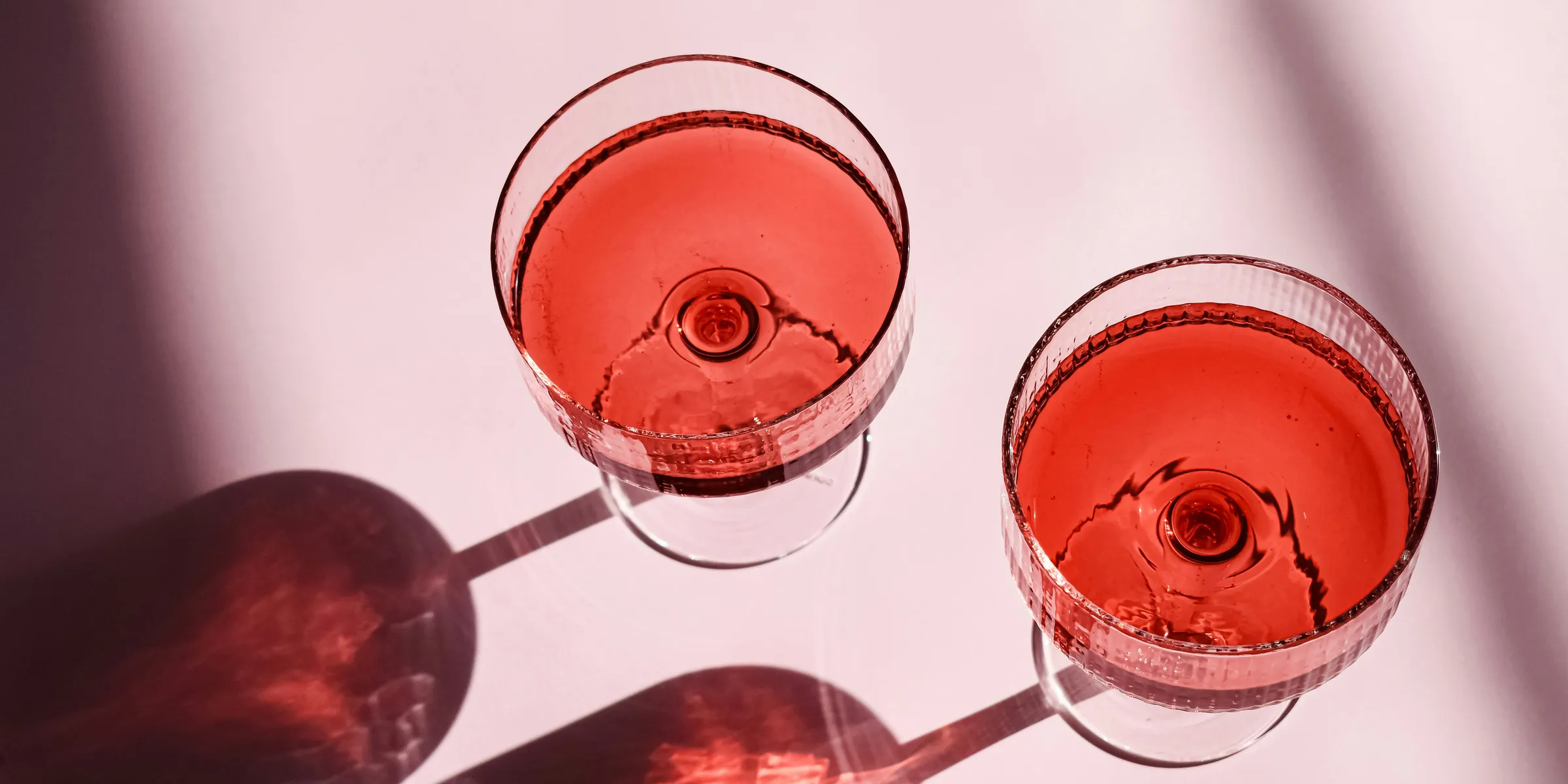 two glasses of red wine sitting next to each other