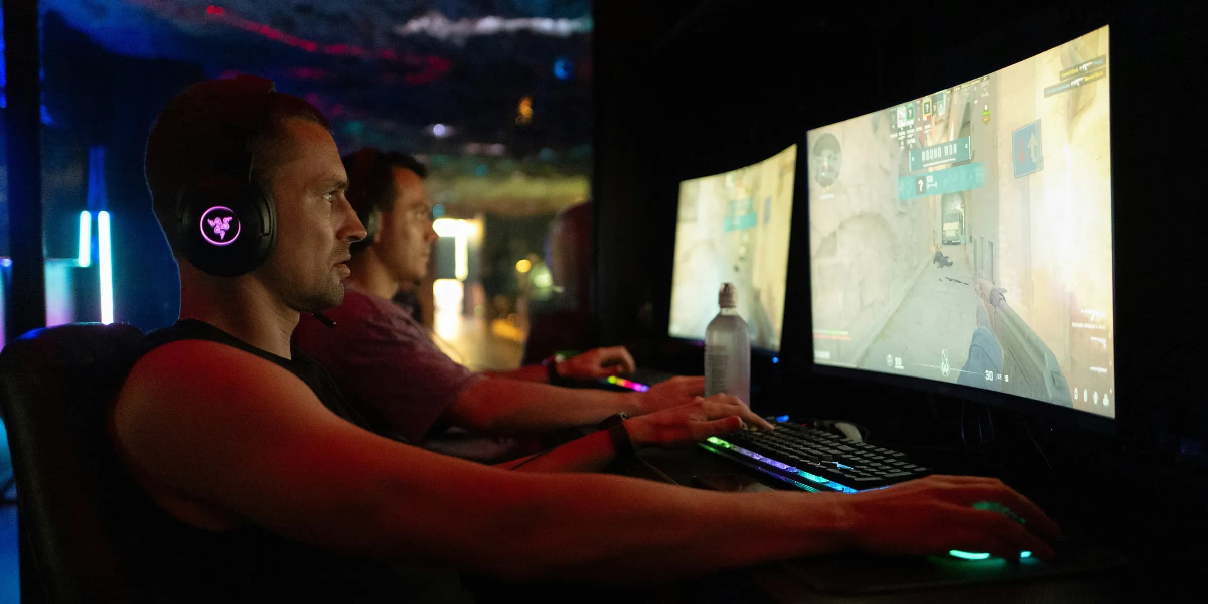 Two men playing video games on computers