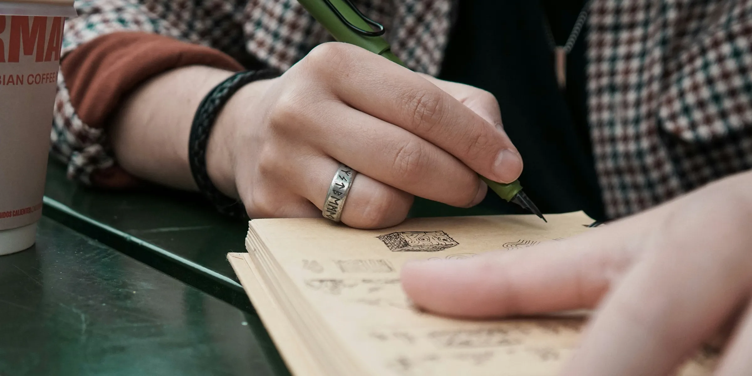 A person sitting at a table writing on a notebook