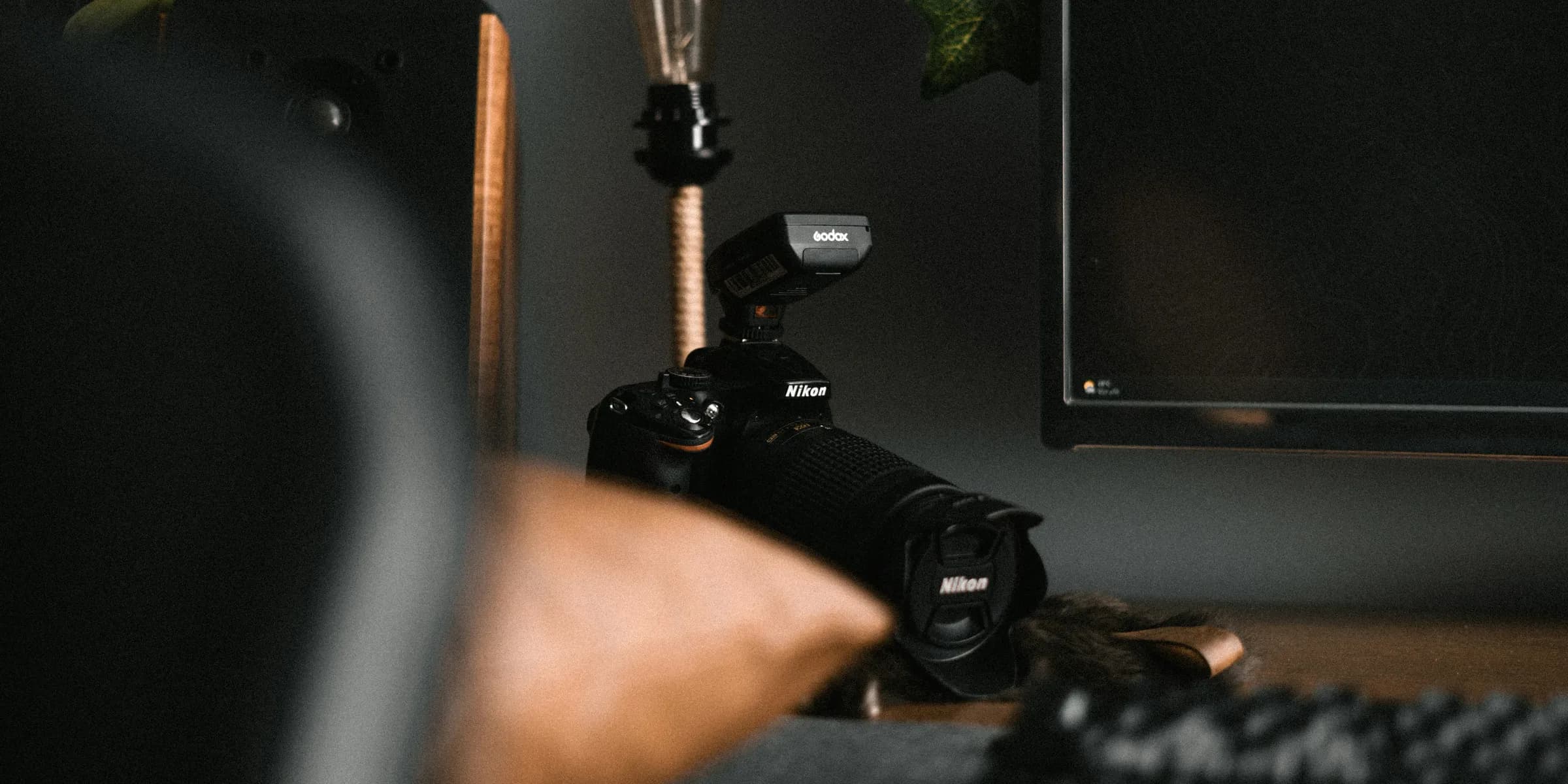 a desk with a monitor, keyboard and a camera
