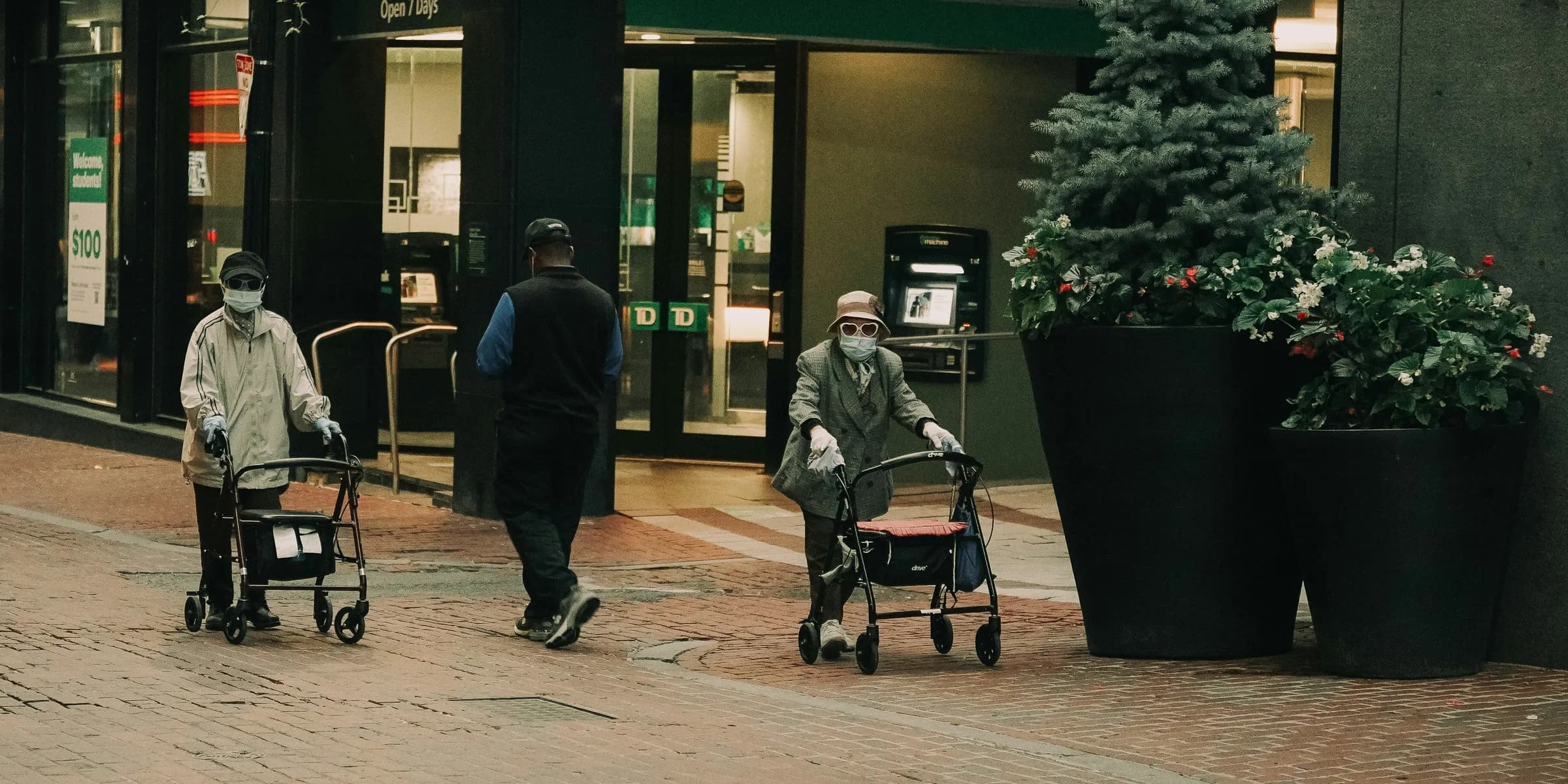 A group of people walking down a street with strollers