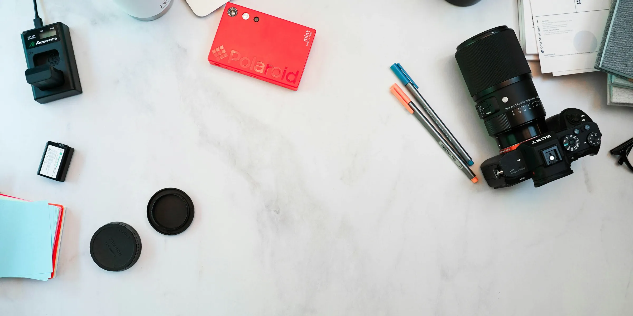a table with a camera, notebooks, and other items on it