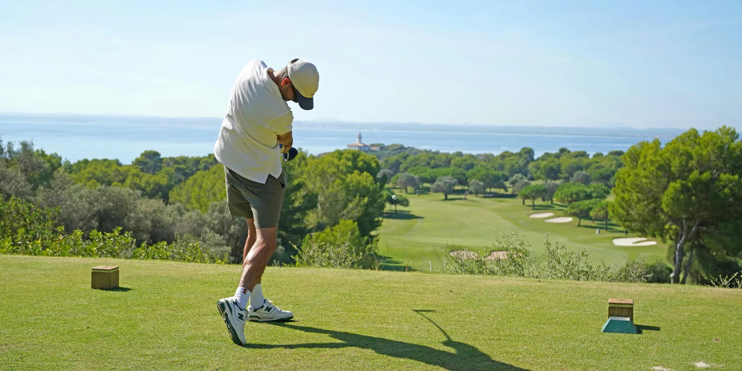 A man swinging a golf club on a golf course