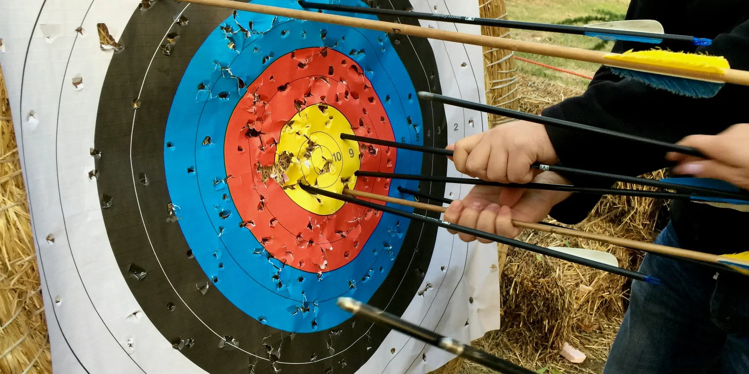 a group of people holding arrows in front of a target