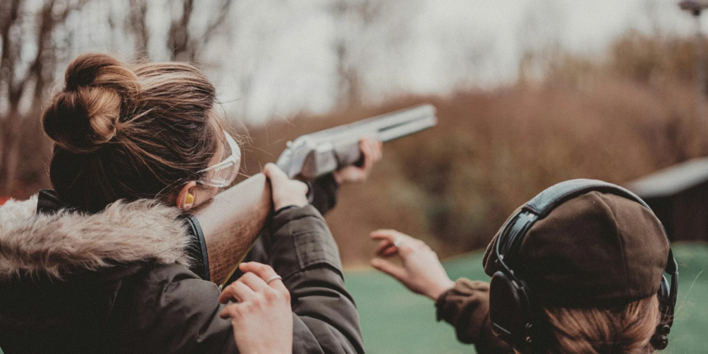 two women are aiming a gun at a target