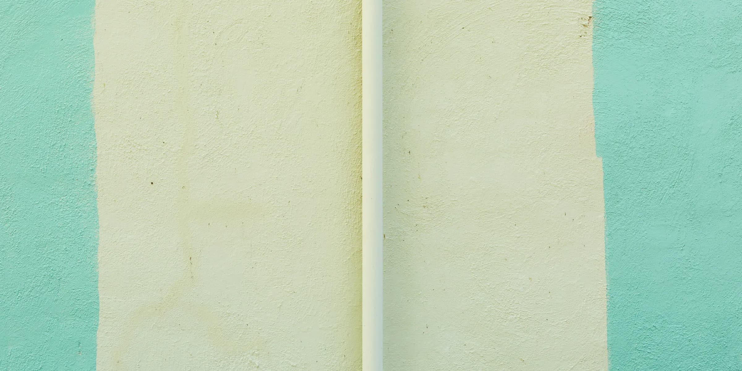 a white surfboard leaning against a blue and green wall