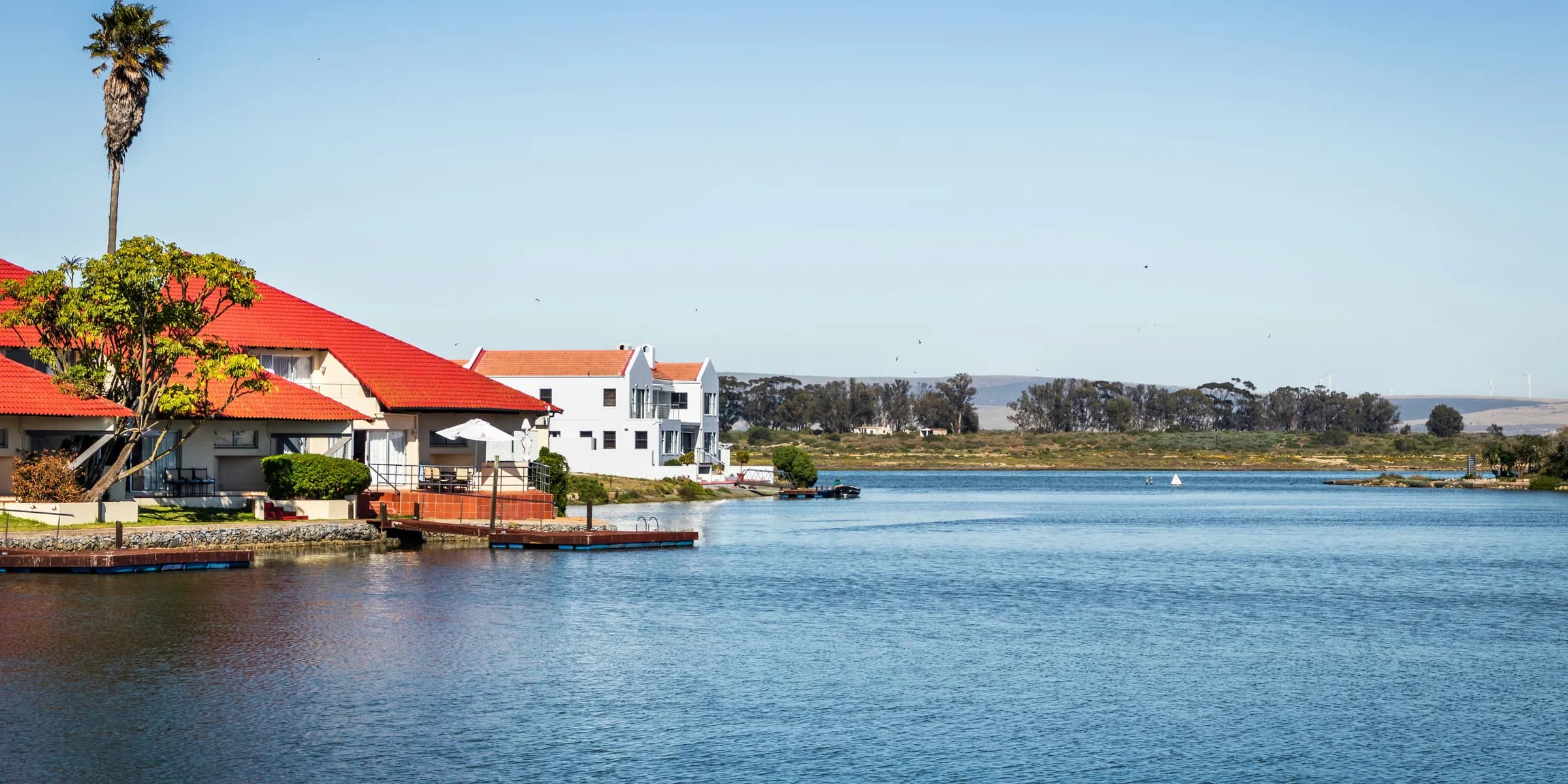 white and brown houses near body of water during daytime