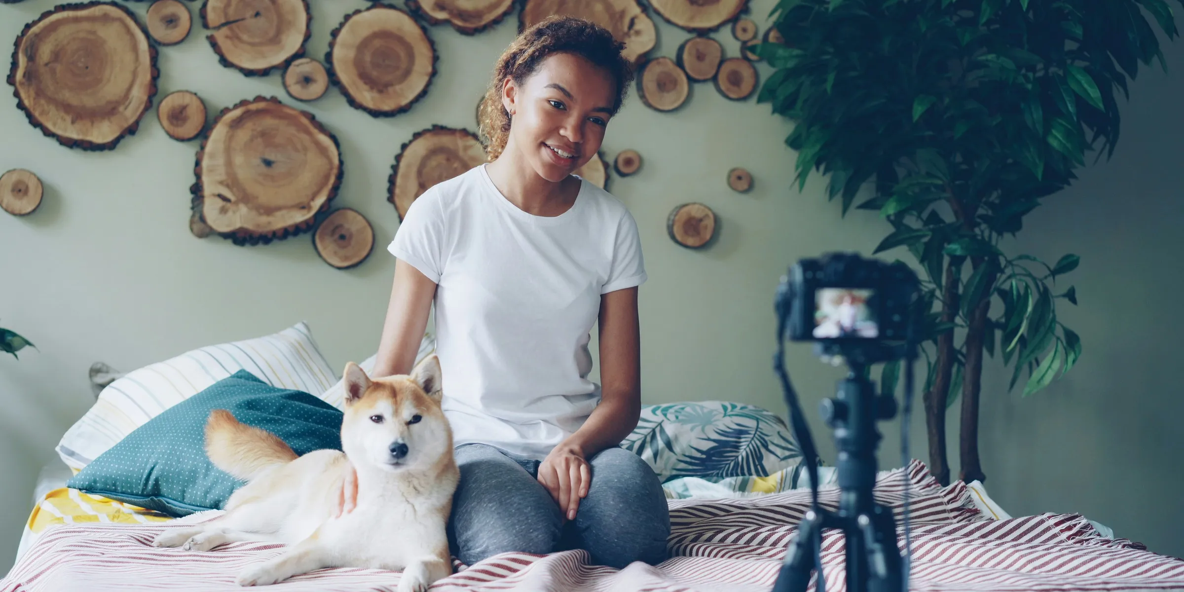 Woman pets a dog while filming a video.
