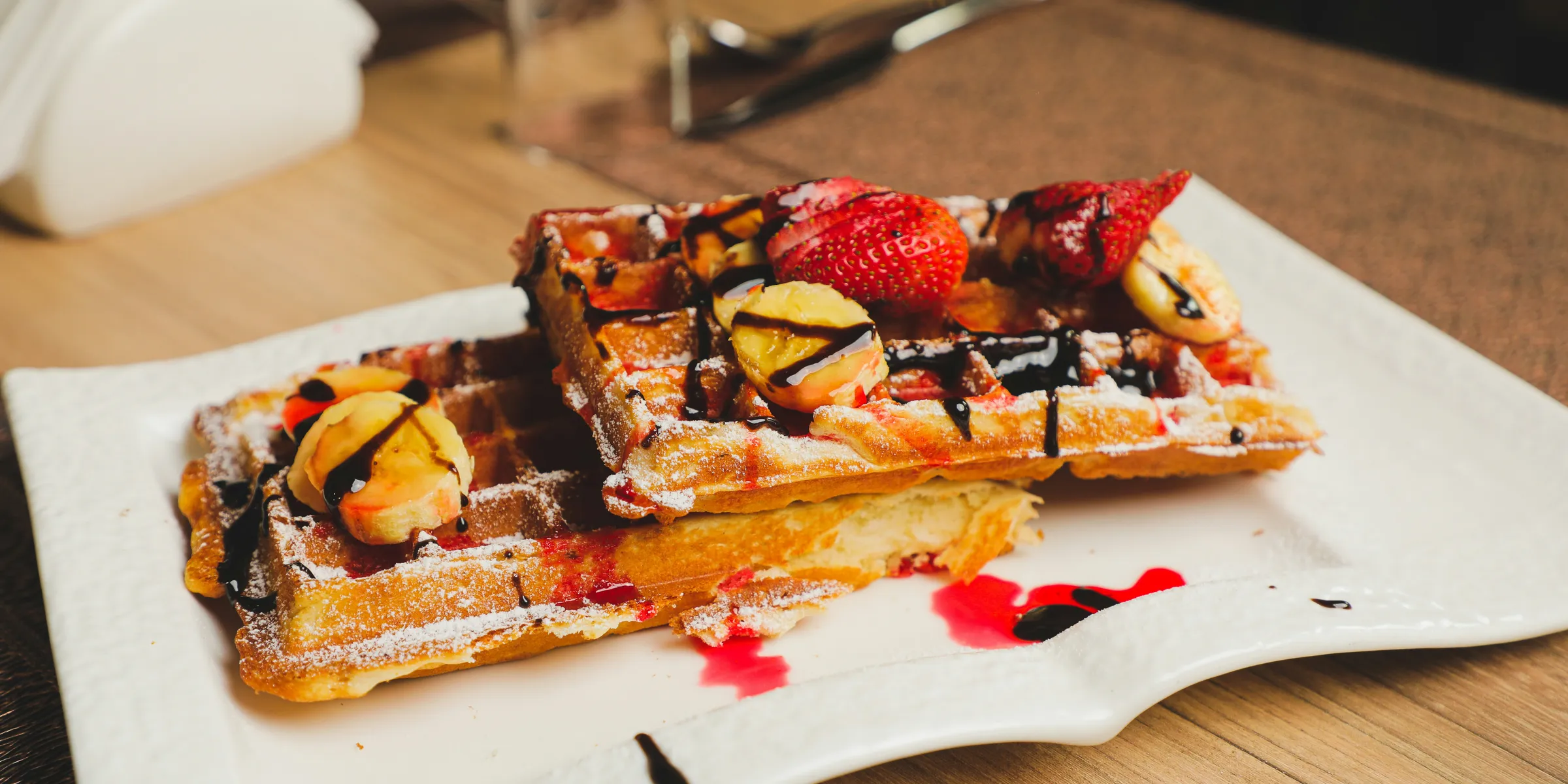 a plate of waffles with fruit on top