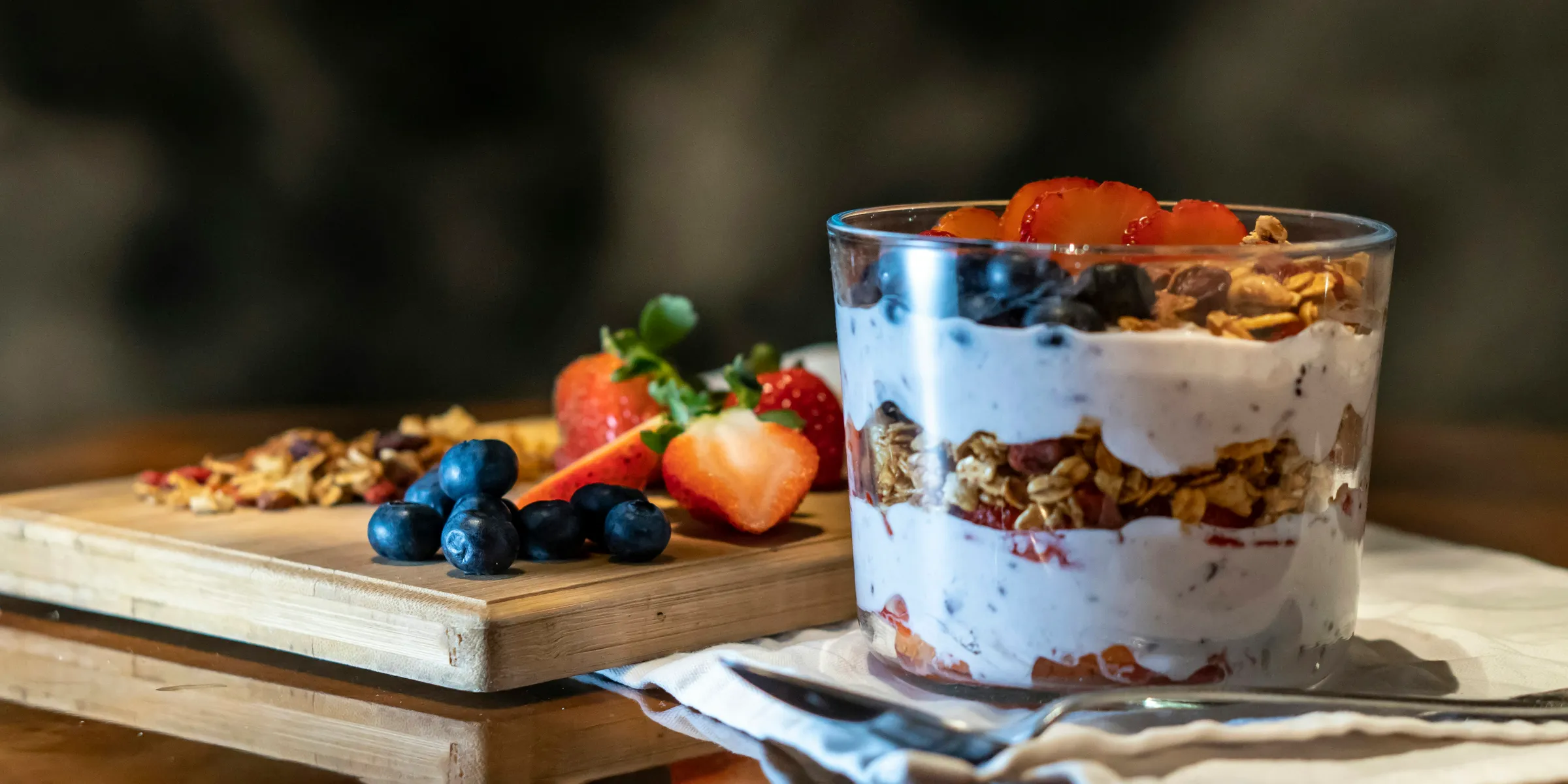 strawberries and cookies with cream filled dessert in glass cup