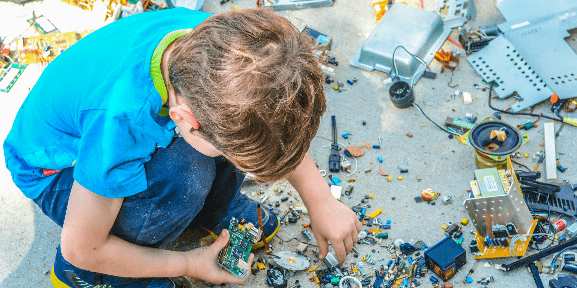 boy sitting while holding electronic device part
