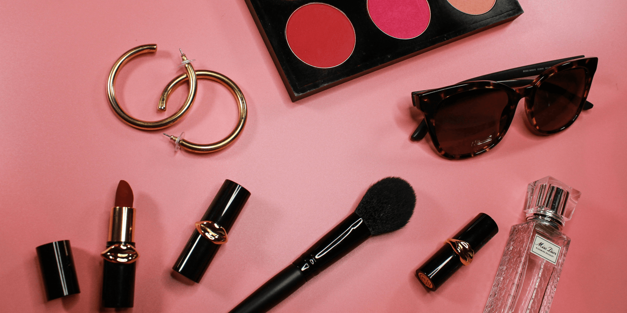 black and pink lipstick on pink surface