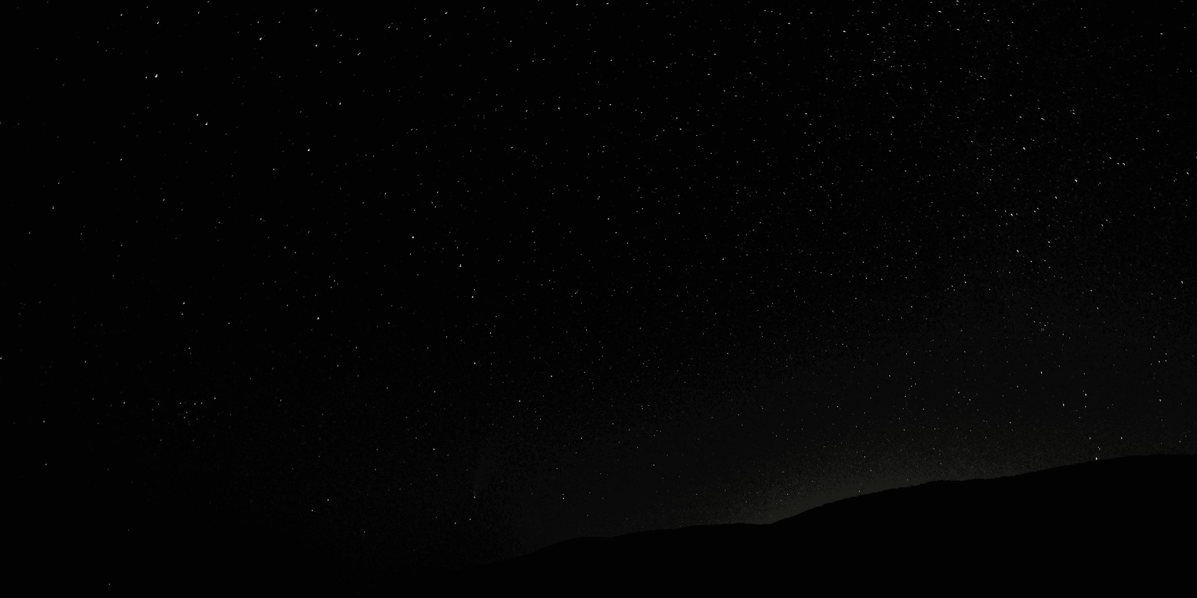 silhouette of mountain under starry night