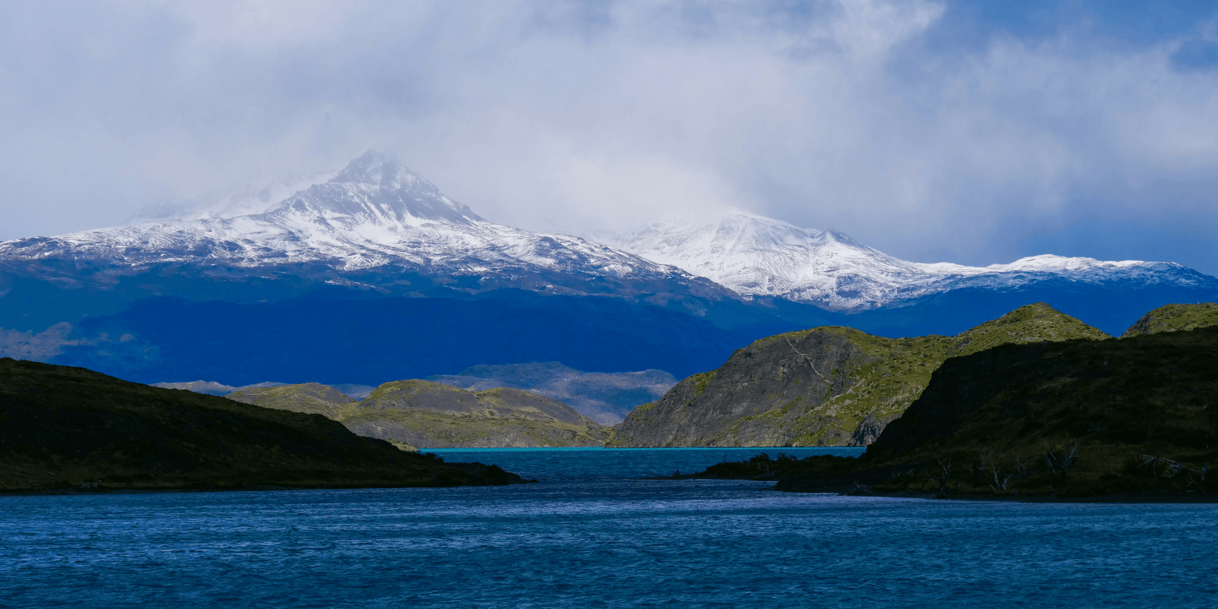 a large body of water with a mountain in the background
