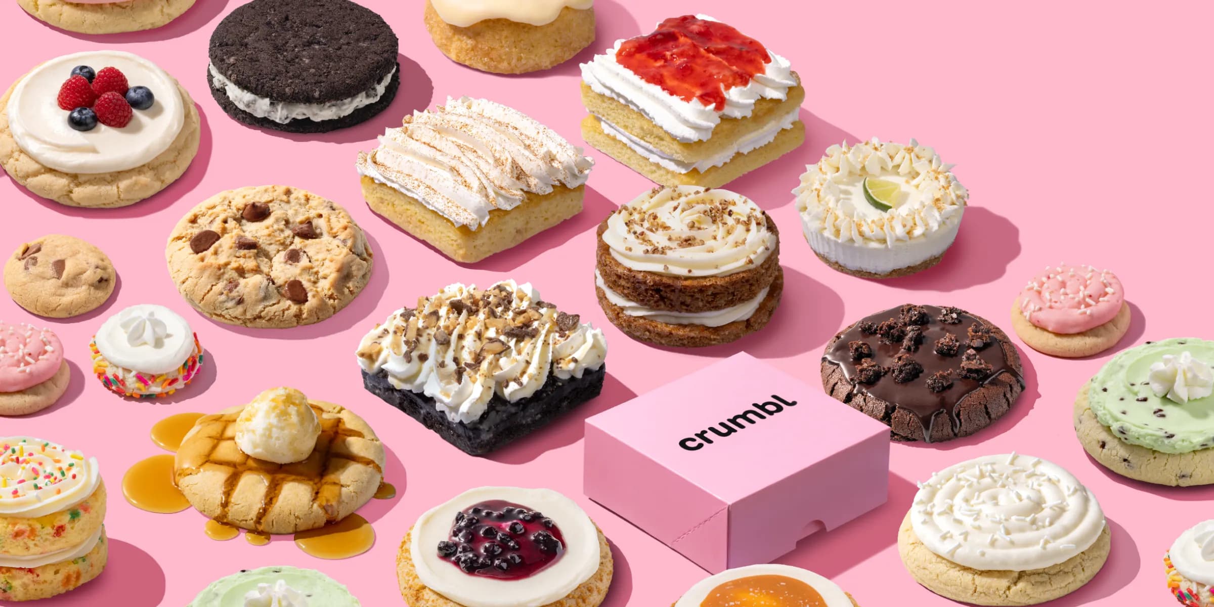 desserts and a box showing the Crumbl Cookies logo on a pink background