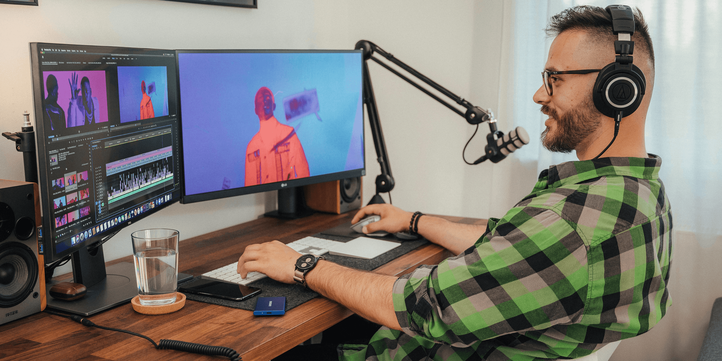 a man wearing headphones and sitting at a desk with a computer.