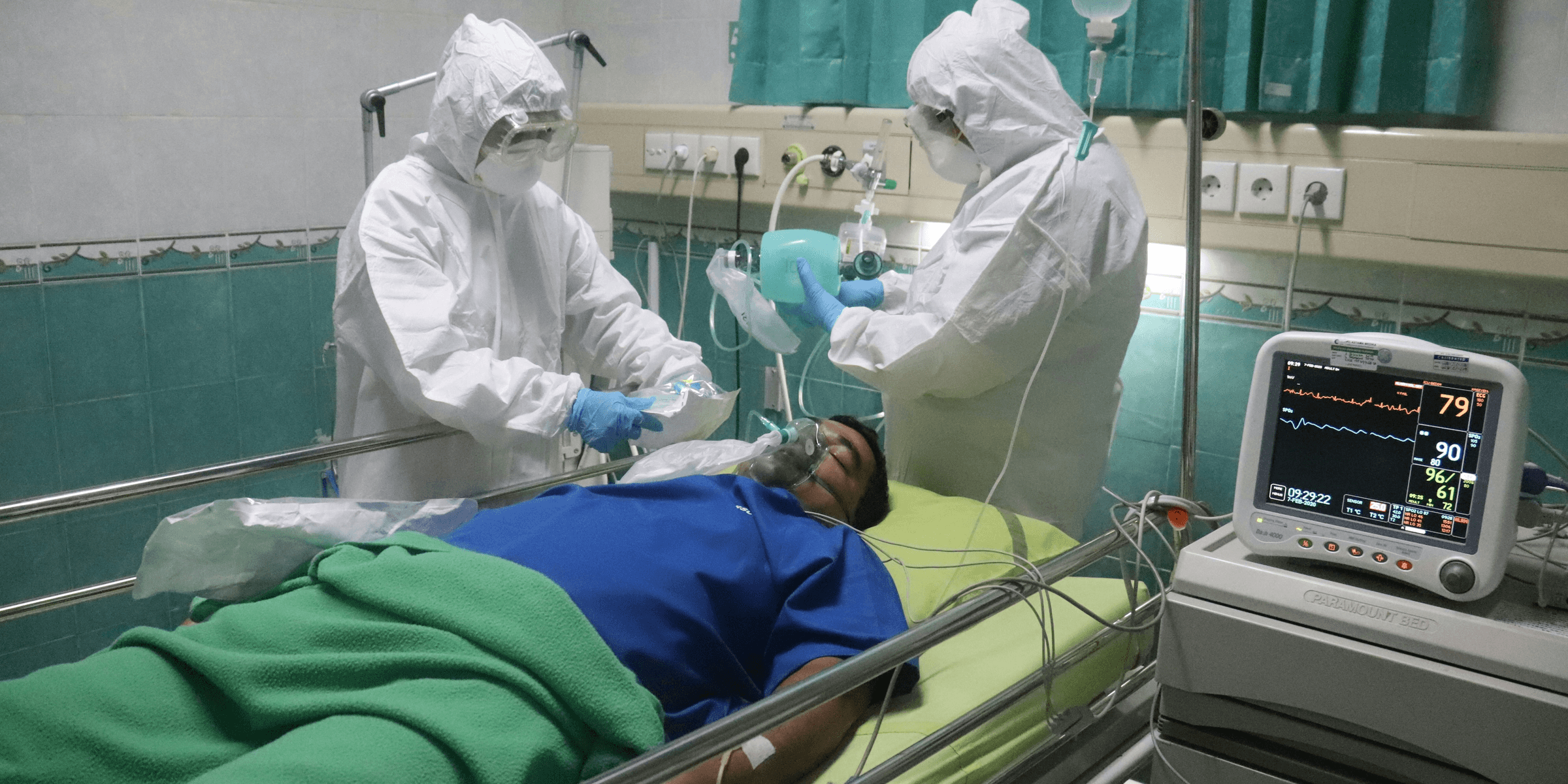 man in white medical scrub lying on hospital bed.