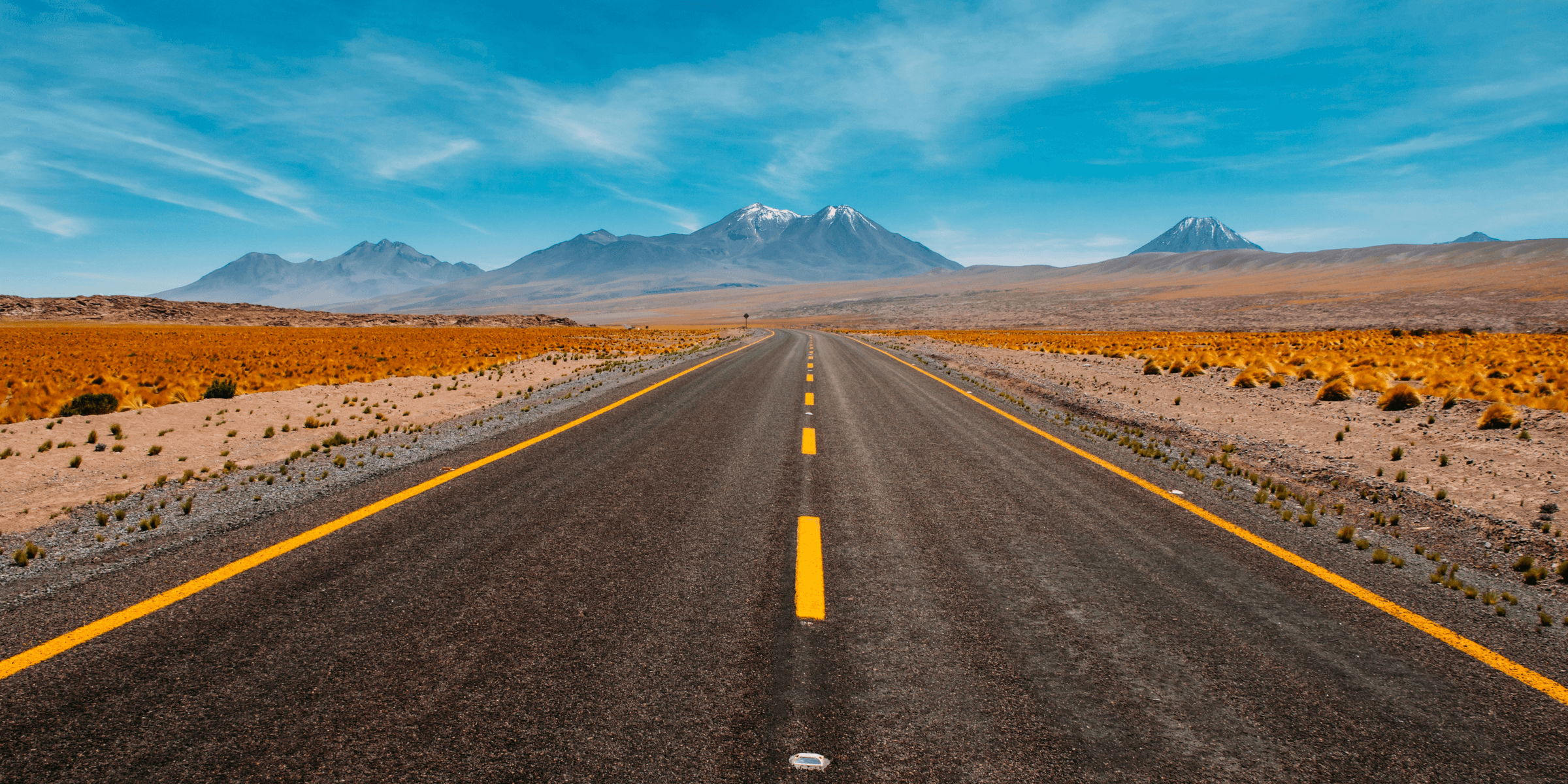 lone road going to mountains.